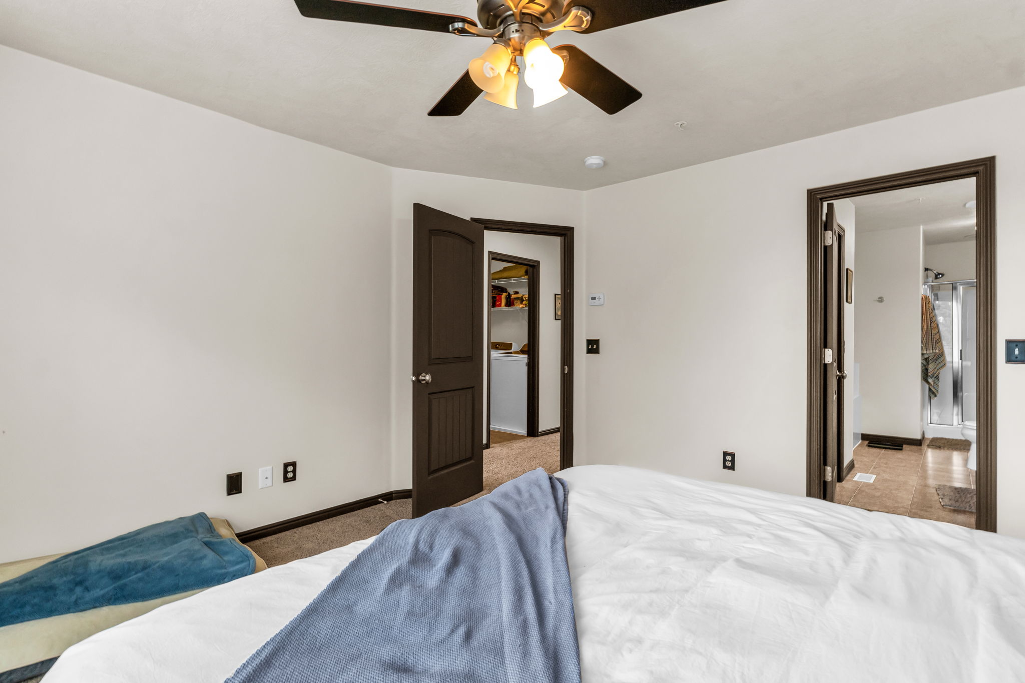 Bedroom featuring a ceiling fan with light fixture, neutral wall paint, and dark trim