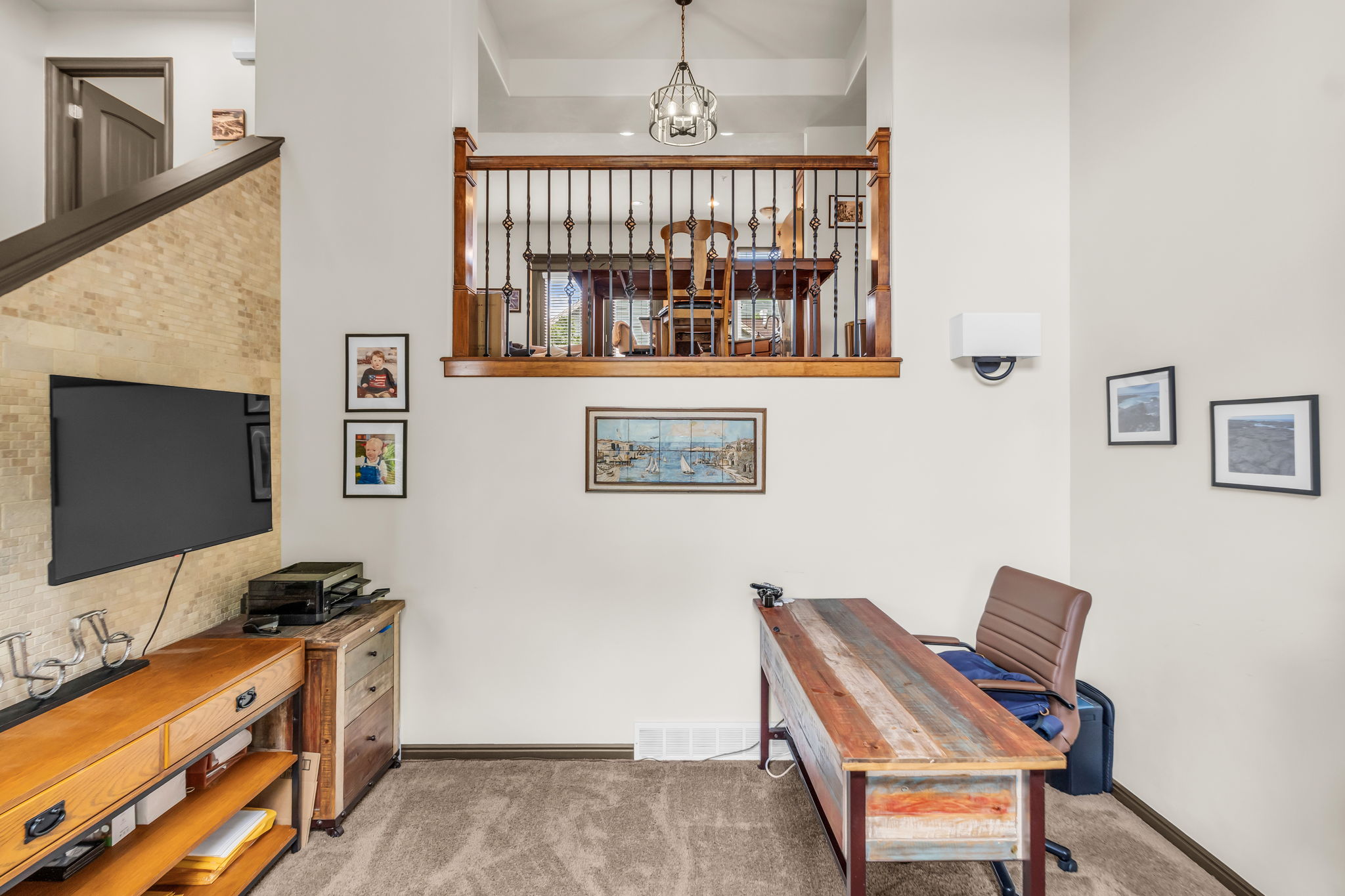 Open floorplan featuring a two-story ceiling, light-toned wall finishes, and a staircase with natural wood and metal balusters