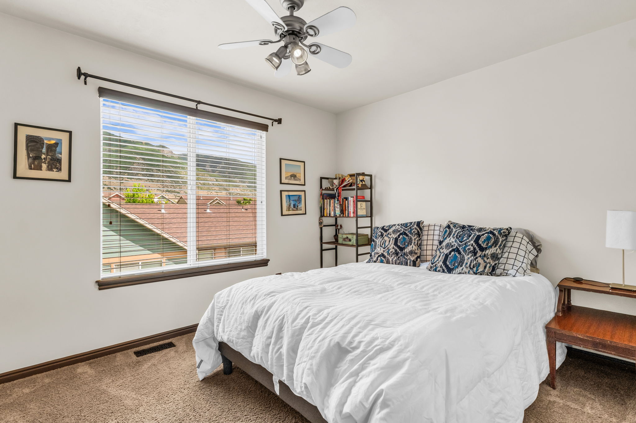 Bedroom featuring a large window with mountain scenery, white walls, and neutral-toned carpet
