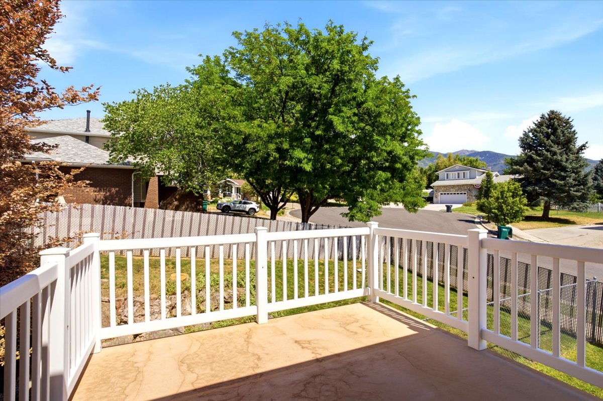 Outdoor patio area featuring a textured concrete surface and white railing