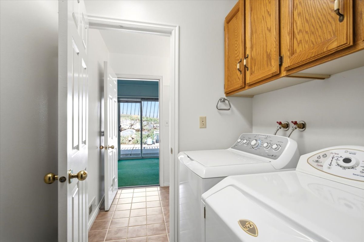 Laundry area featuring wood cabinetry and tile flooring