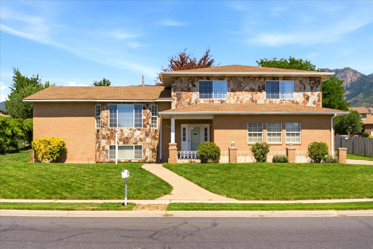 Two-story residence featuring a brick facade with natural stone accents