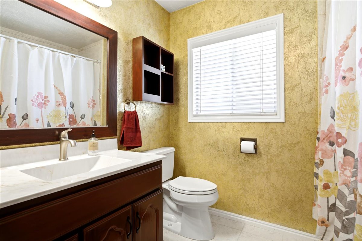 Bathroom featuring a vanity with a white countertop and dark wood-finish cabinetry