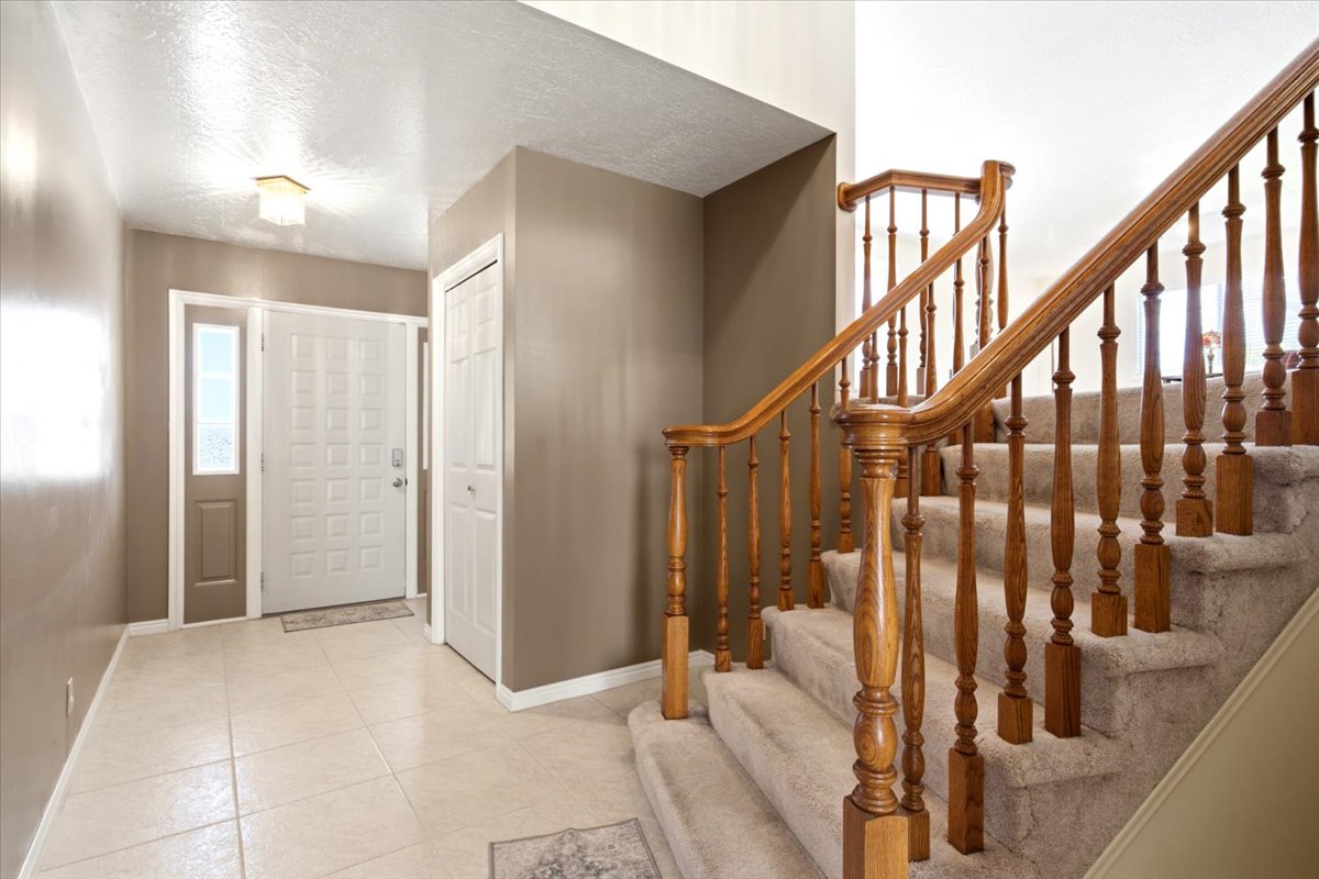 Entryway featuring a paneled door with sidelight, tile flooring, and a built-in closet