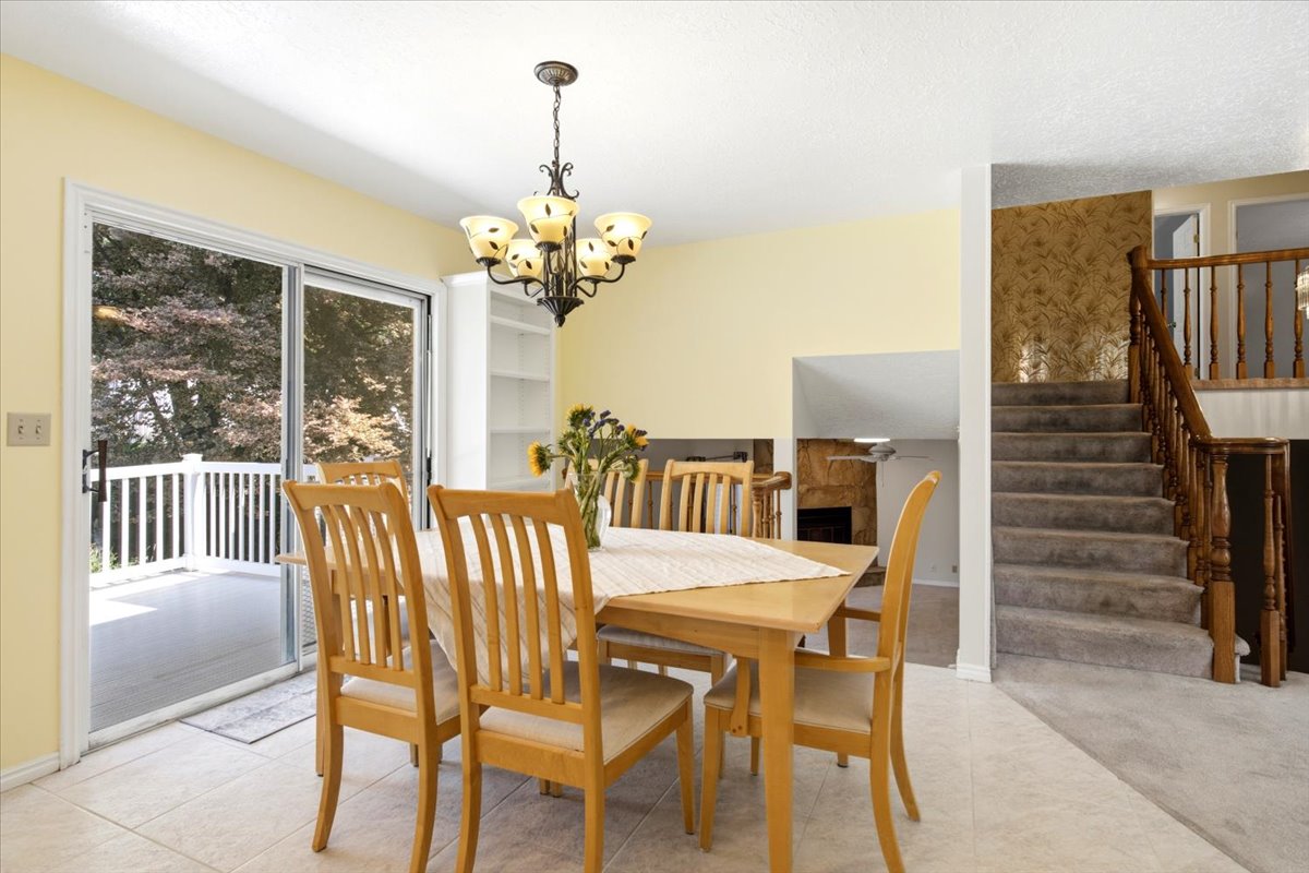 Dining area featuring a bronze-finish chandelier, built-in shelving, and tile flooring