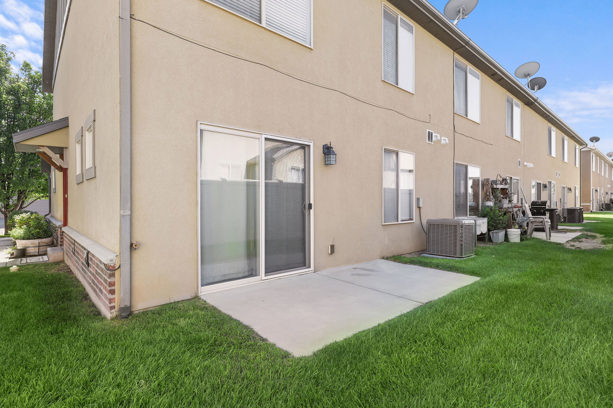 Back exterior featuring a sliding glass door, a concrete patio, and a stucco finish
