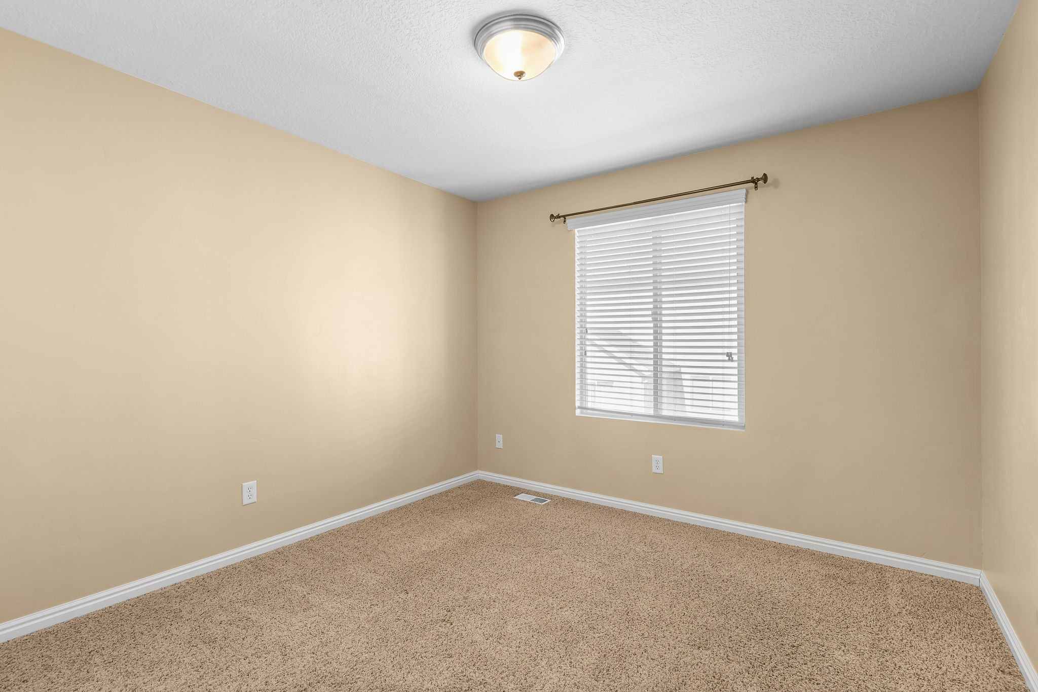 Neutral-toned walls complement the textured carpet flooring
