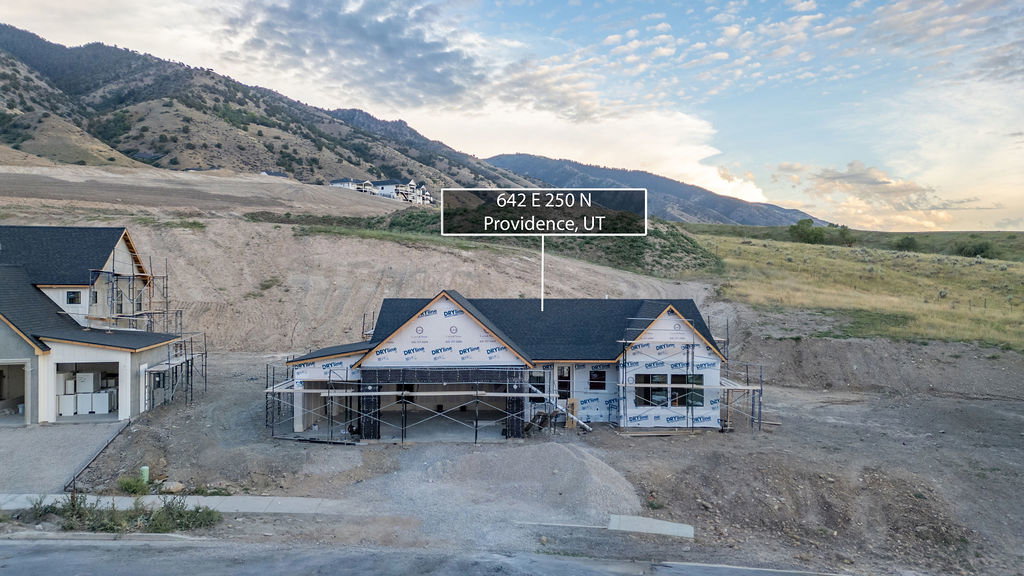 New construction home framed with sheathing, black roof shingles, and multiple windows