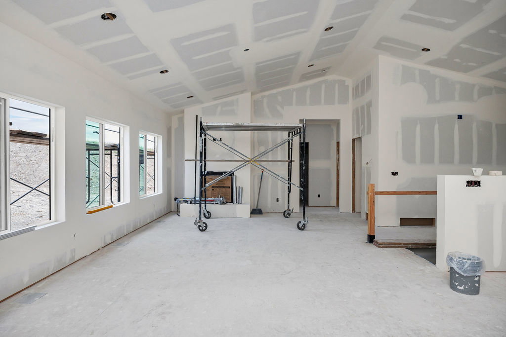 Spacious interior room under construction featuring multiple windows