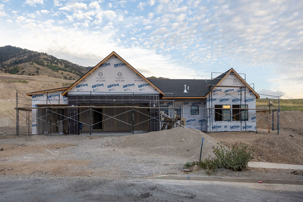 New construction property featuring a shingled roof, multiple gables, and a prominent mountain backdrop