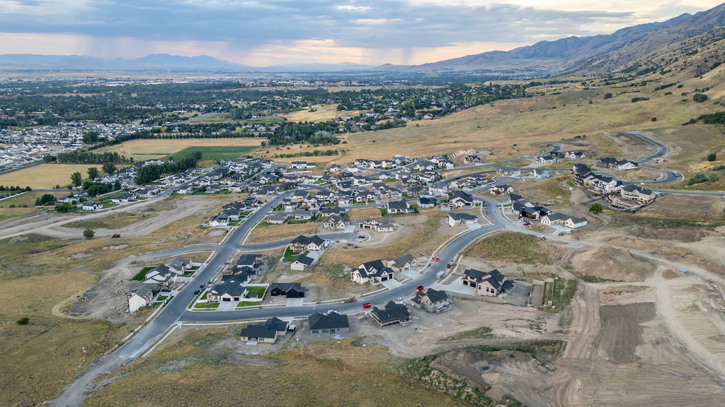 Aerial perspective showcasing a developing residential community with paved streets and established homes