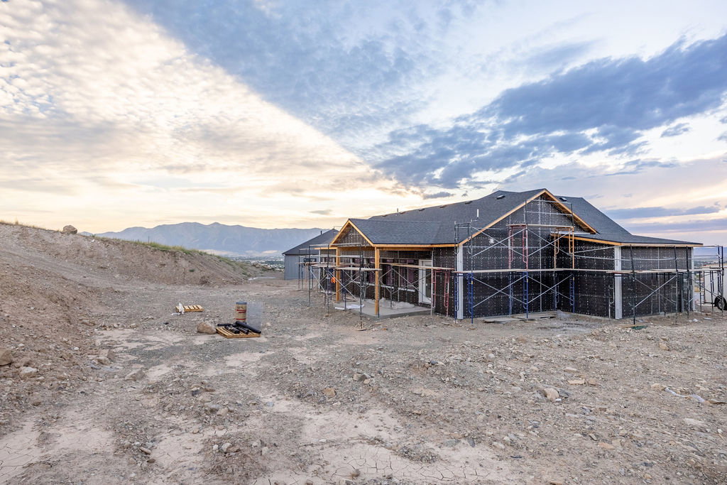 Newly constructed property featuring a dark shingle roof and structural framing