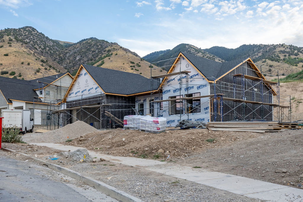 New construction property with a shingle roof and mountain backdrop