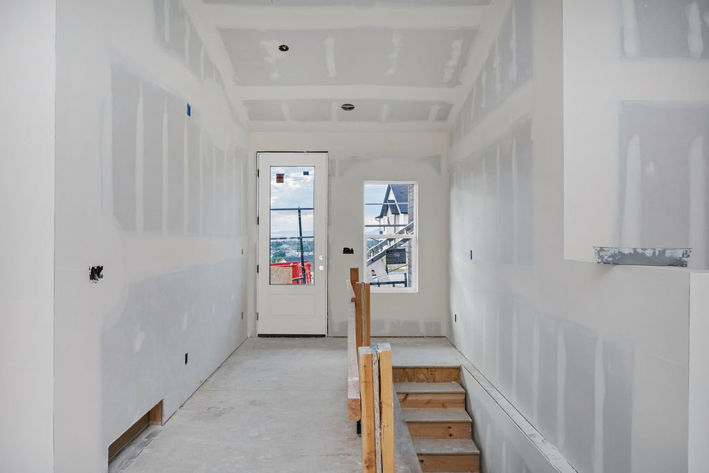 Entryway featuring a full-light panel door, an interior window, and a descending staircase with wooden treads