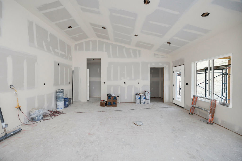 Spacious interior framing, featuring vaulted ceilings with recessed lighting rough-ins, multiple window openings, and an exterior door with glass panels