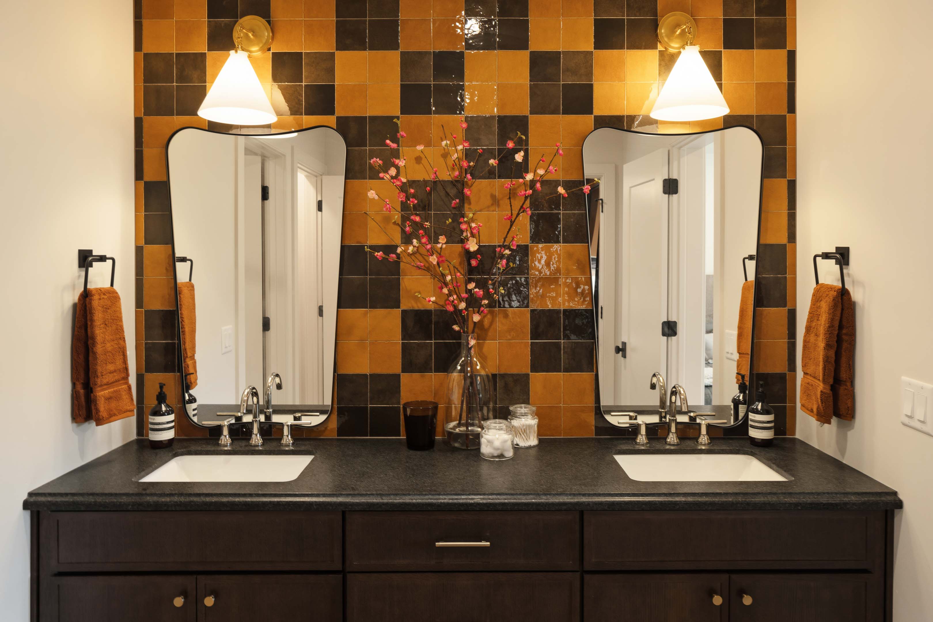 Dual vanity with a dark wood-finish cabinet, dark countertop, and integrated sinks