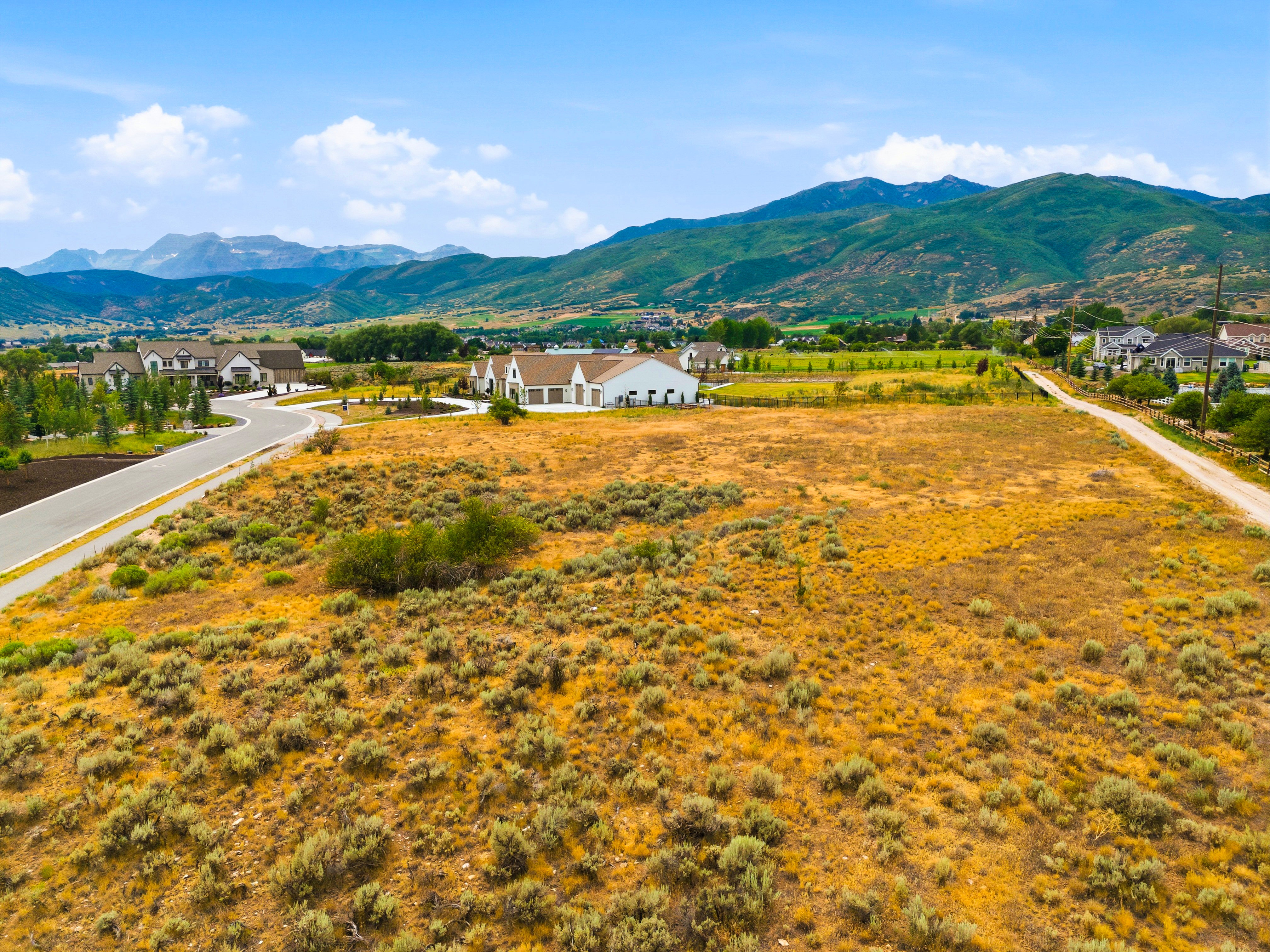 Expansive undeveloped land featuring natural shrubbery and a mountainous backdrop