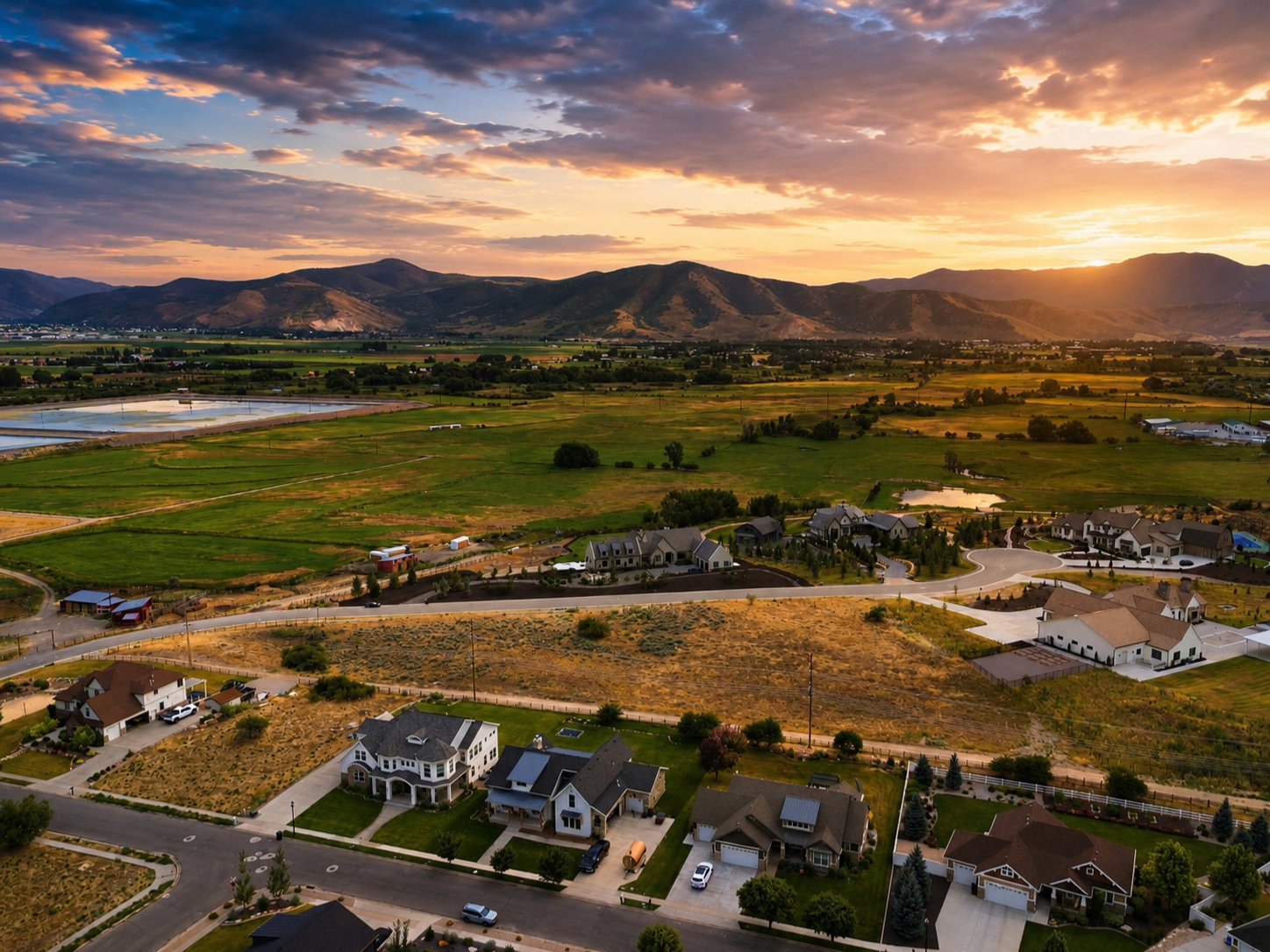 Aerial perspective showcasing residential properties within a developed neighborhood, framed by expansive natural landscaping and distant mountains