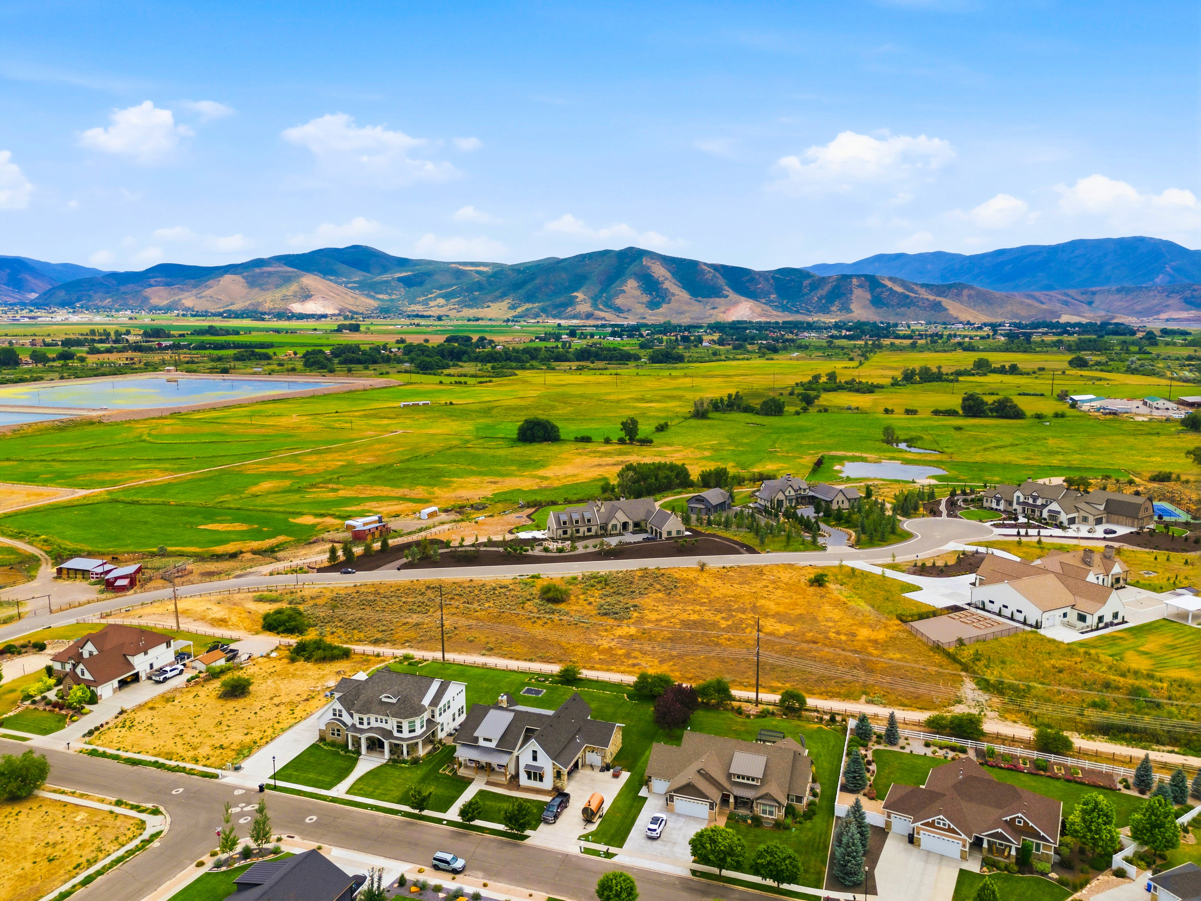 Expansive rural landscape with distant mountains and a mixture of agricultural fields and residential developments