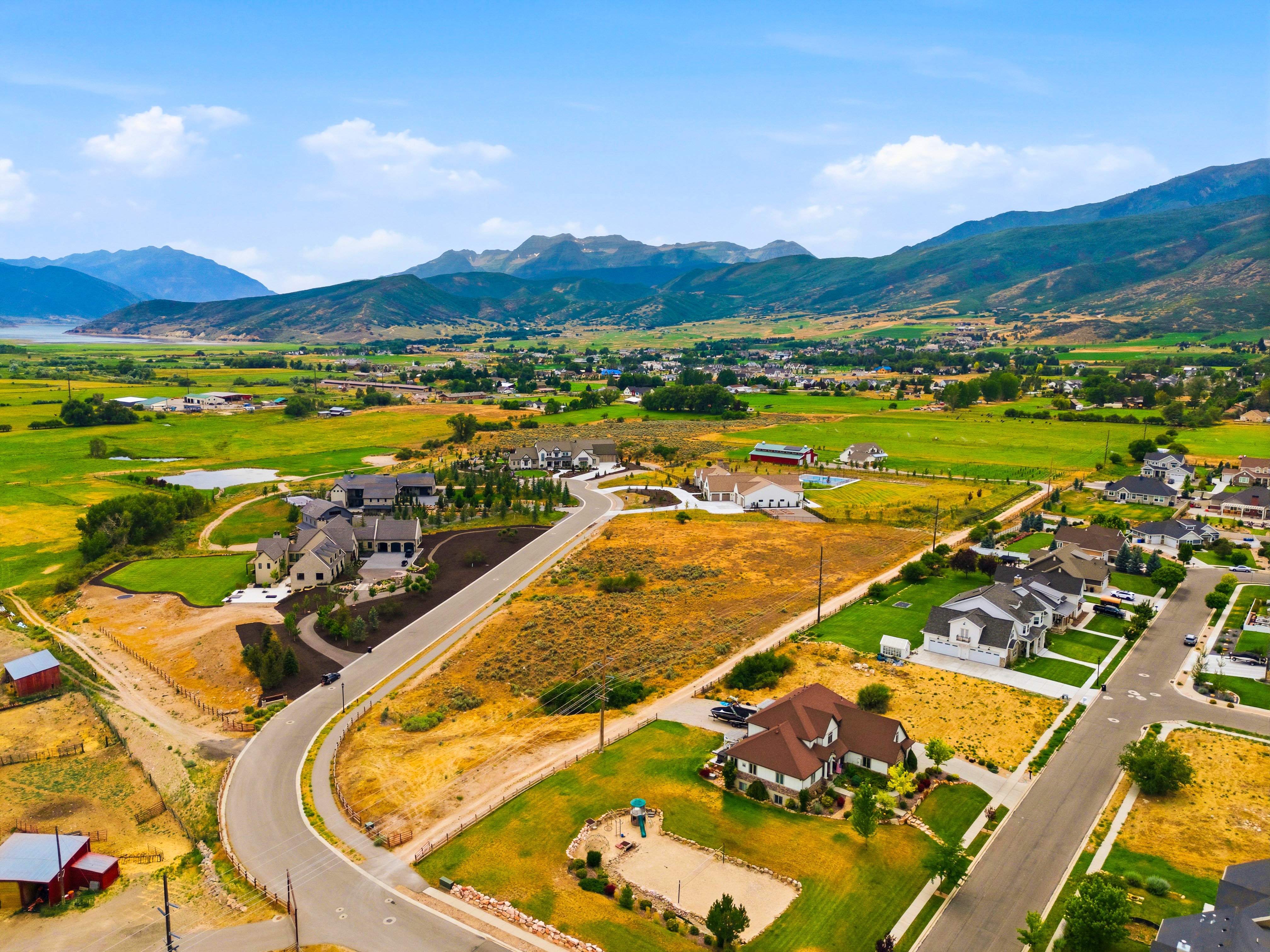 Expansive aerial perspective showcasing a residential development with mountain and distant water features