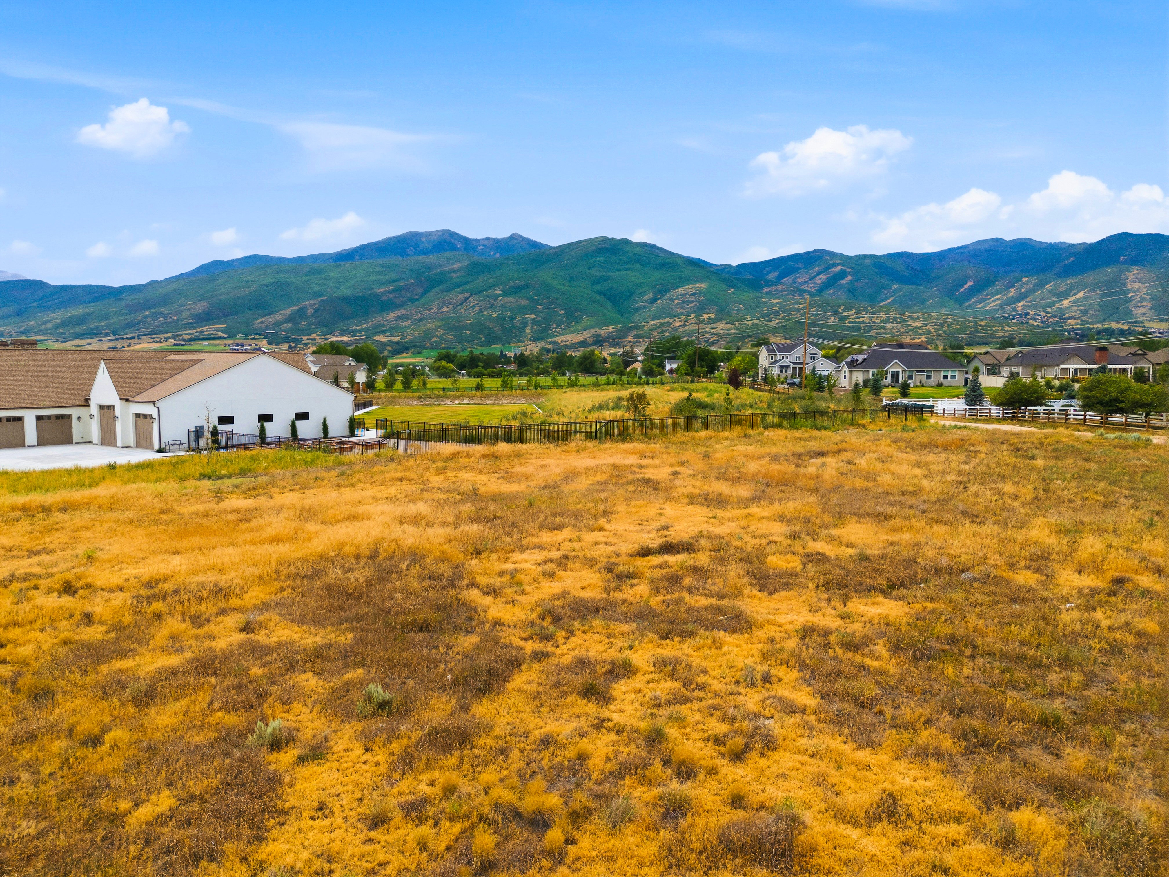 Expansive land parcel featuring natural, dry ground cover and distant mountain ranges