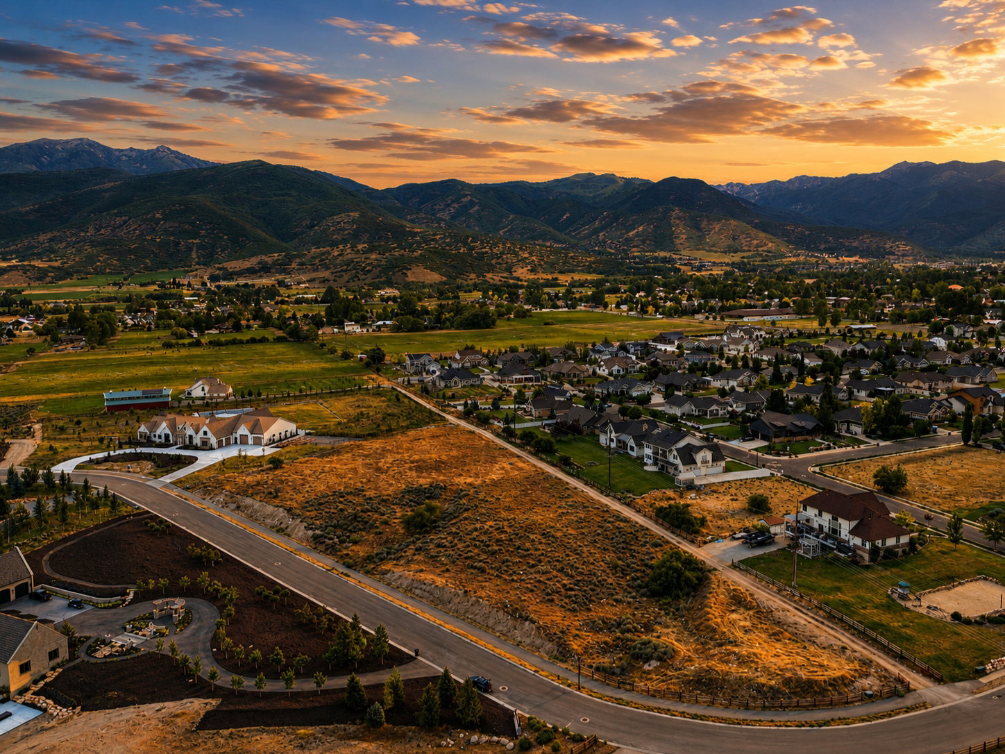 Expansive residential area featuring numerous single-family homes, surrounding undeveloped land, and paved roads