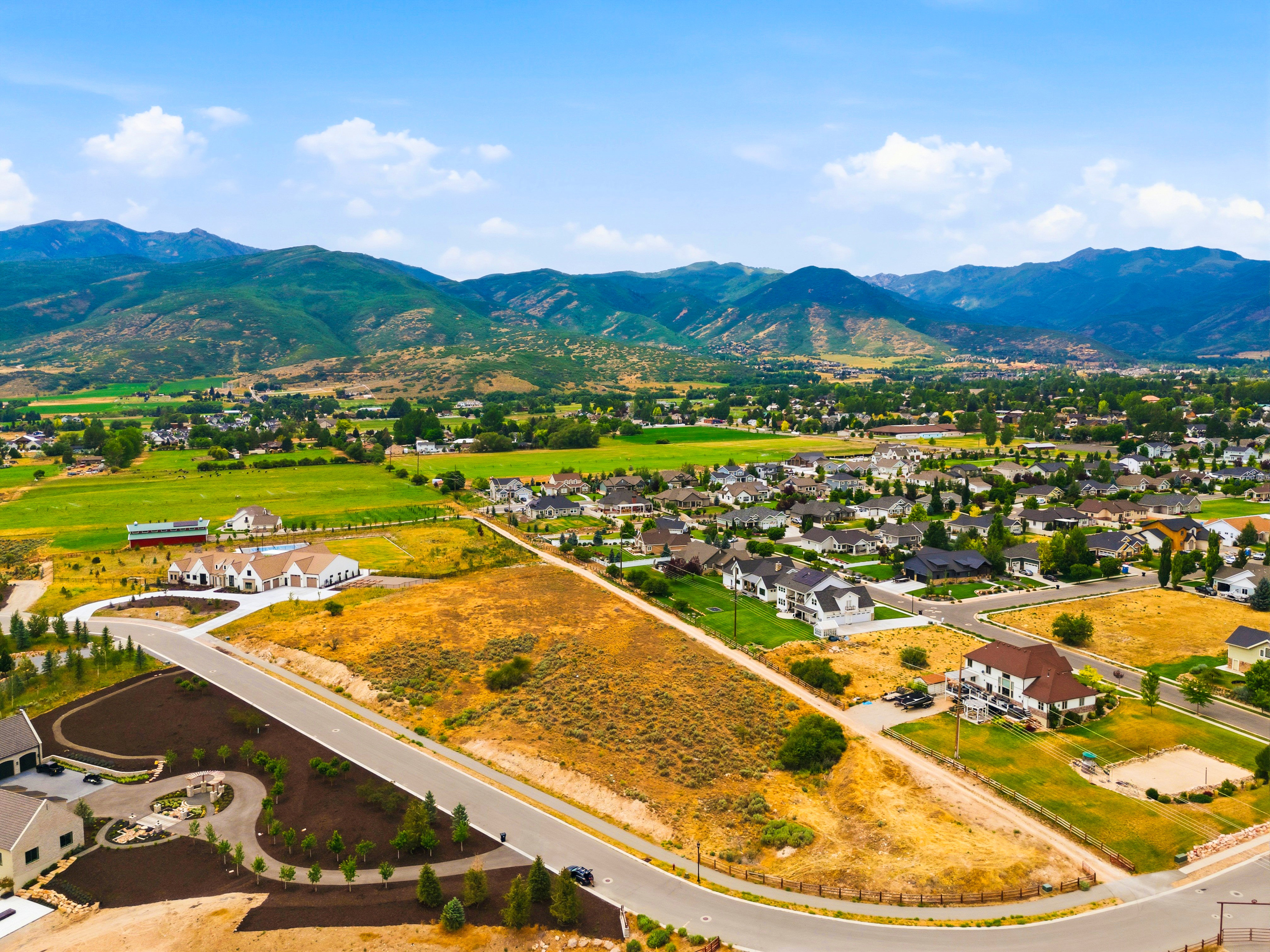 Aerial perspective showcasing a residential community with single-family homes, established landscaping, and paved roads