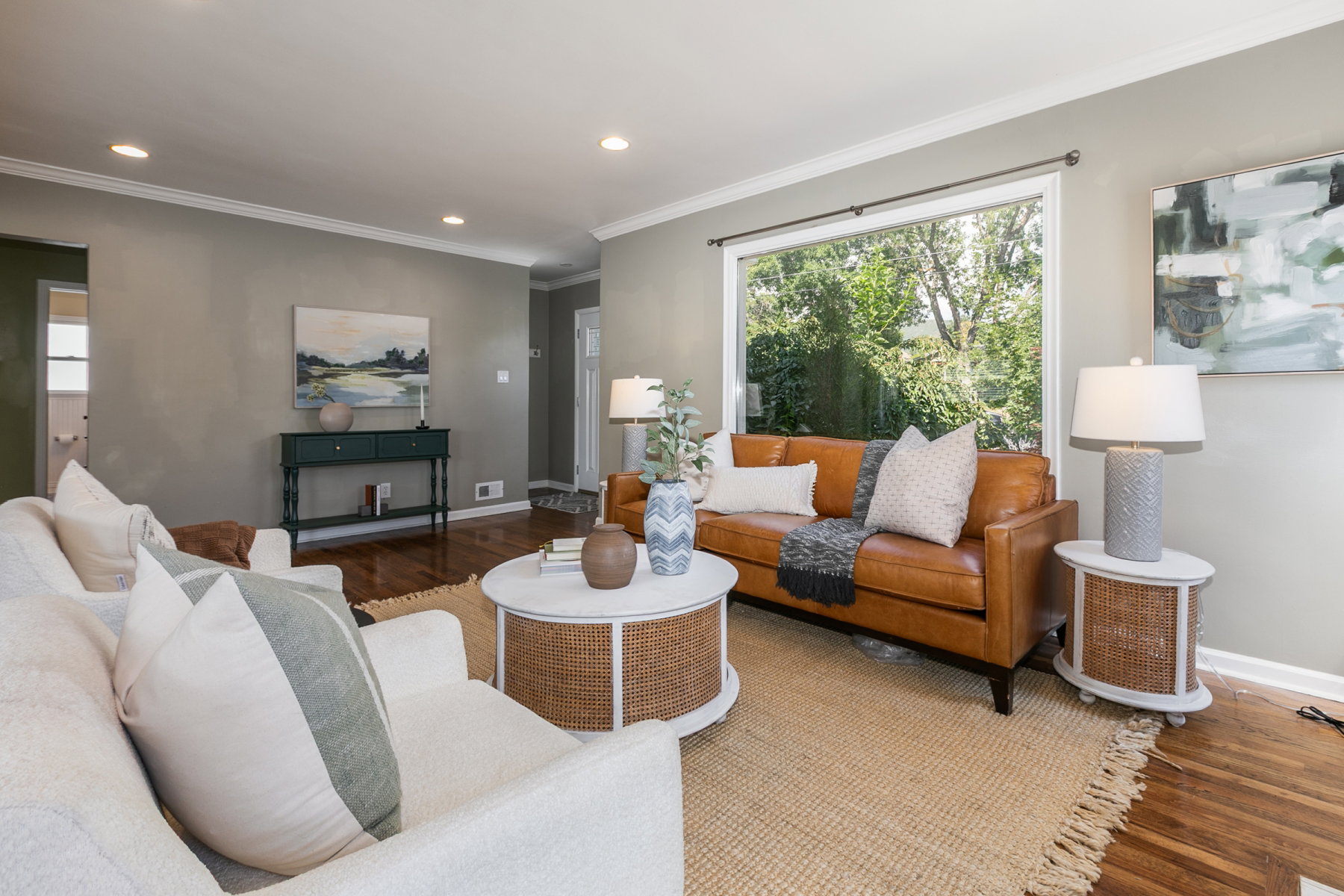 Spacious living area featuring polished wood-finish flooring, a large picture window, recessed lighting, and crown molding