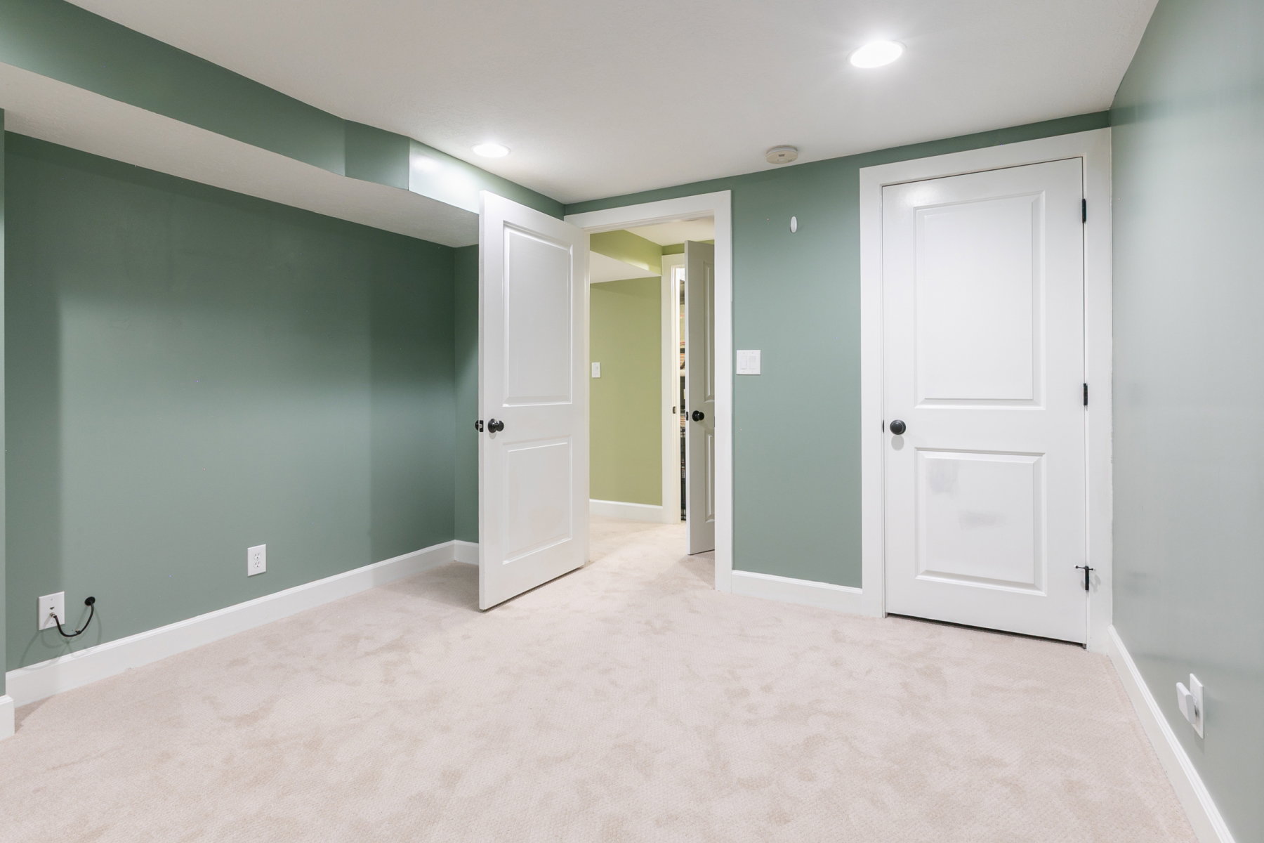 Spacious room featuring plush carpeting, recessed lighting, and crisp white trimwork