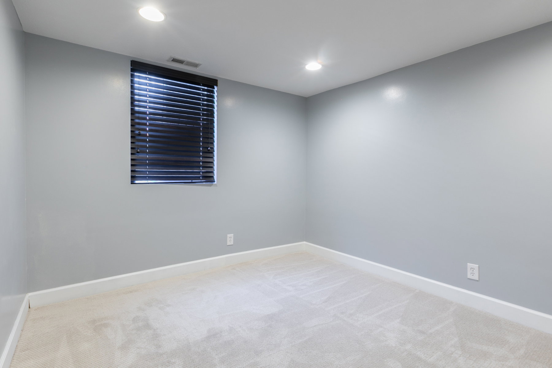 Room featuring light gray walls, recessed lighting, and a window with dark blinds