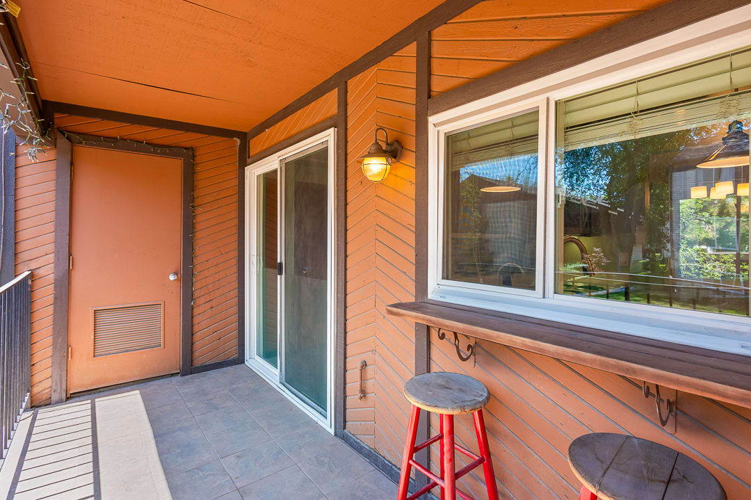 Private balcony featuring textured wood siding, tile flooring, and a built-in wood-finish counter