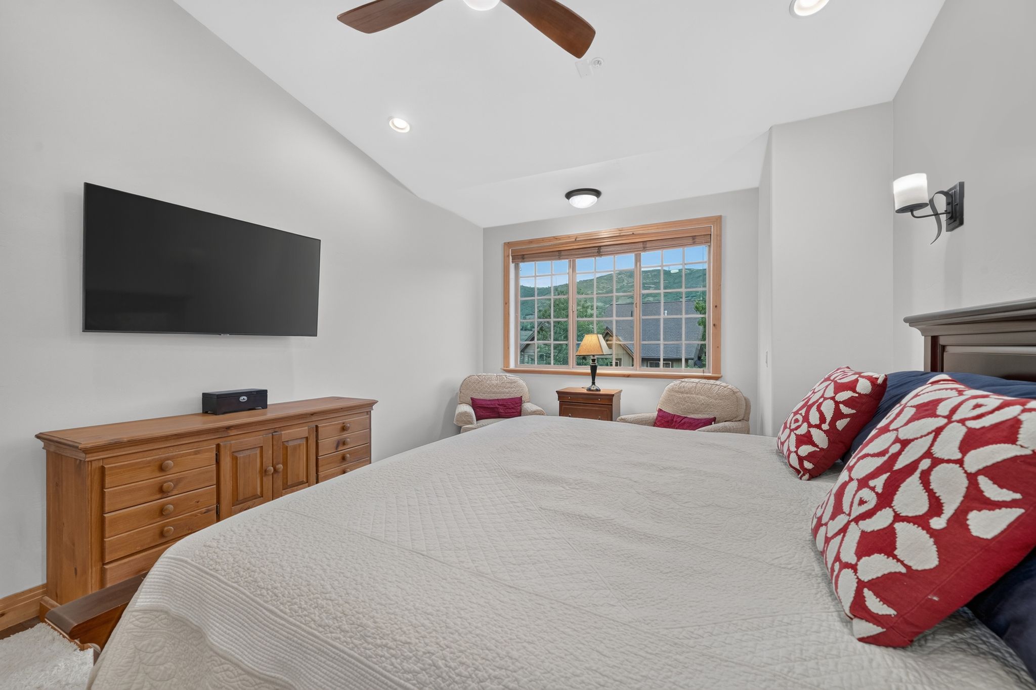 Bedroom featuring a large window with mountain scenery, a vaulted ceiling, recessed lighting, and a dark wood ceiling fan