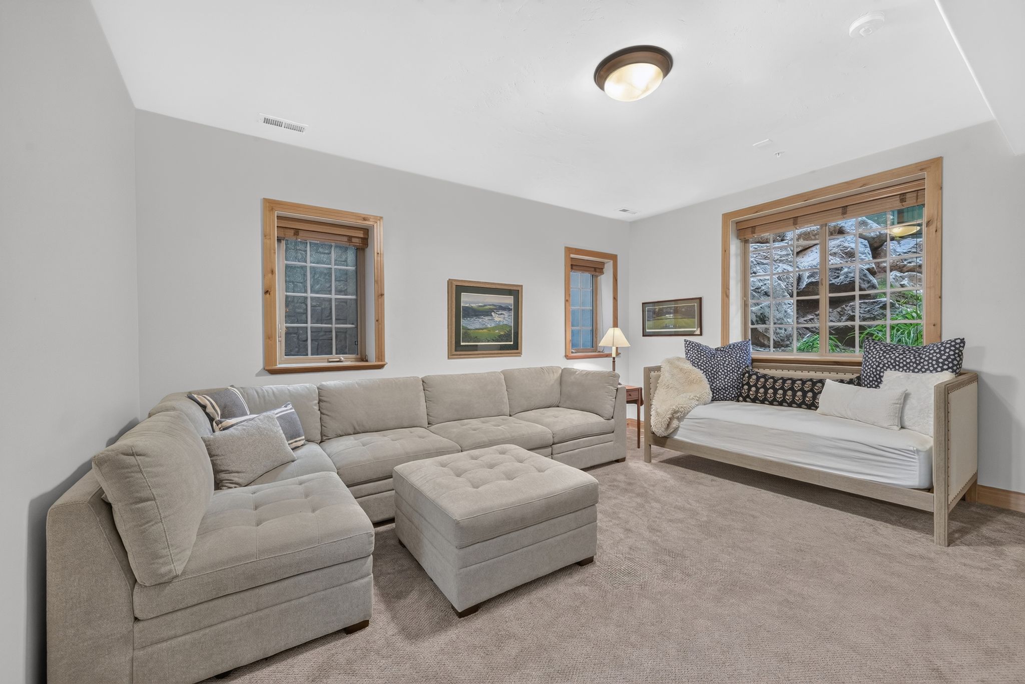 Neutral wall paint, light-toned carpeting, and natural wood window trim create a versatile interior space