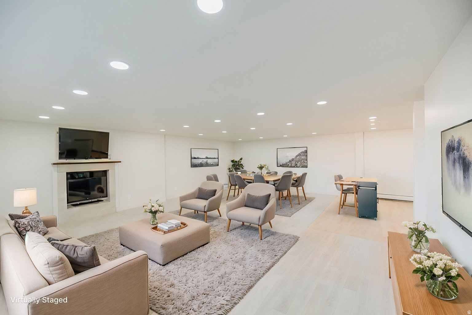 Spacious open-concept interior featuring light-toned walls, recessed lighting, and a prominent fireplace with a wood mantel
