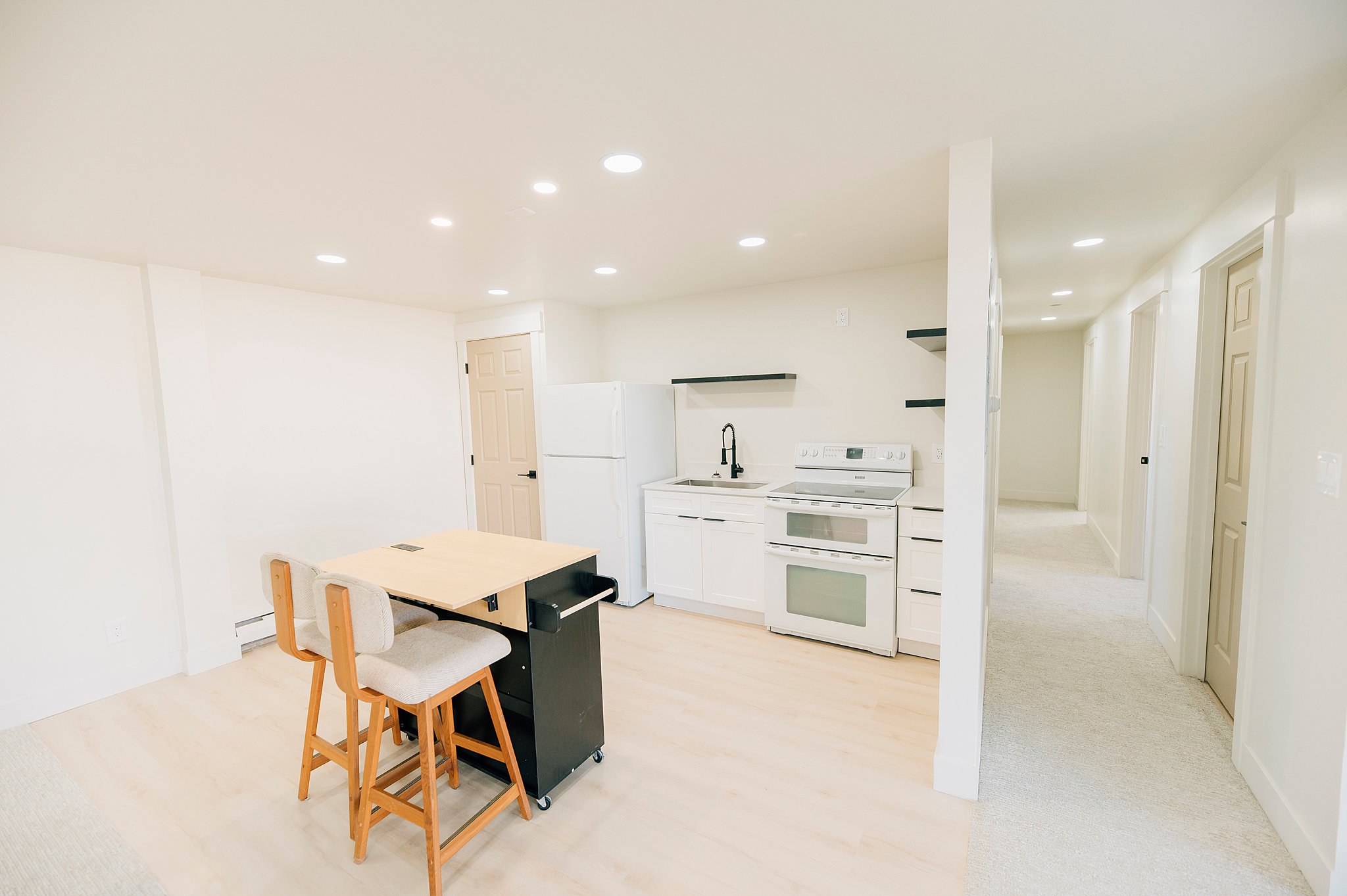 Compact kitchen space featuring white cabinetry, a white electric range with a double oven, and a white refrigerator