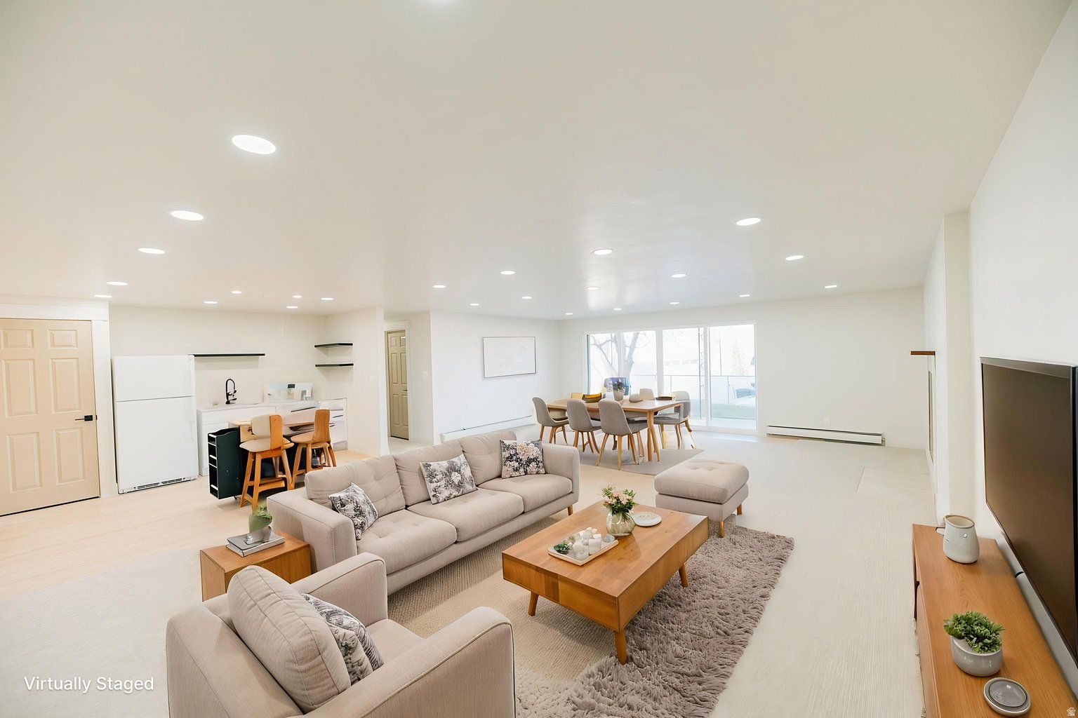 Open-concept interior featuring light-toned flooring, recessed lighting, a modern wet bar with open shelving, and a dining area with sliding glass doors