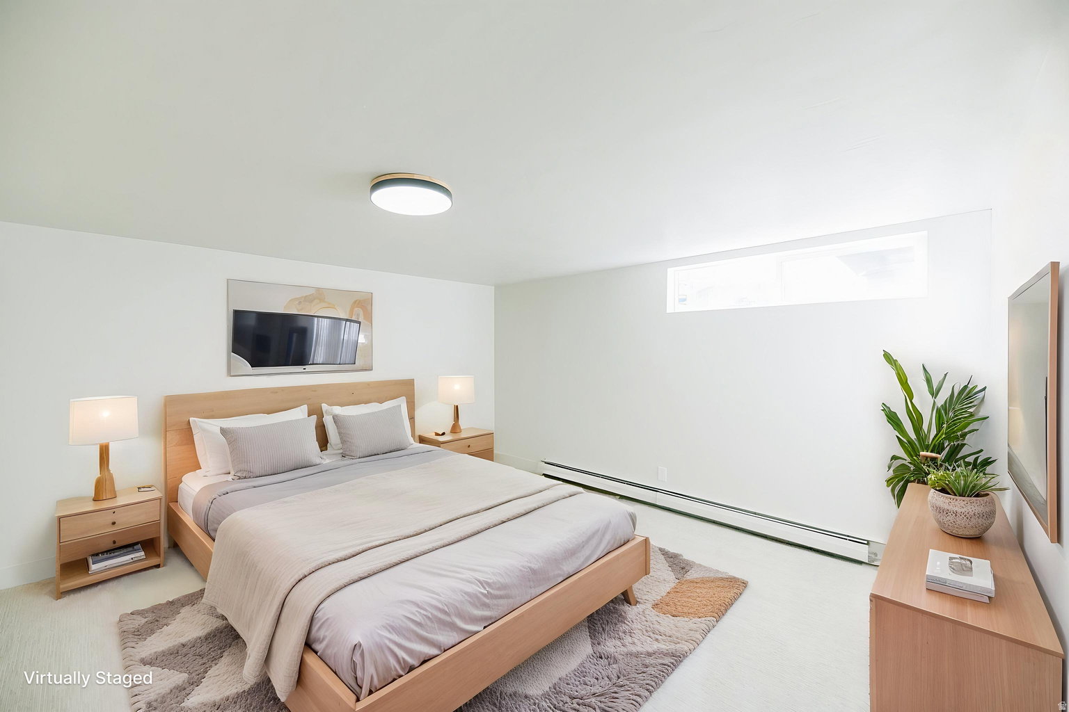 Bright sleeping area featuring white walls, light wood-finish flooring, and a flush-mount ceiling light fixture