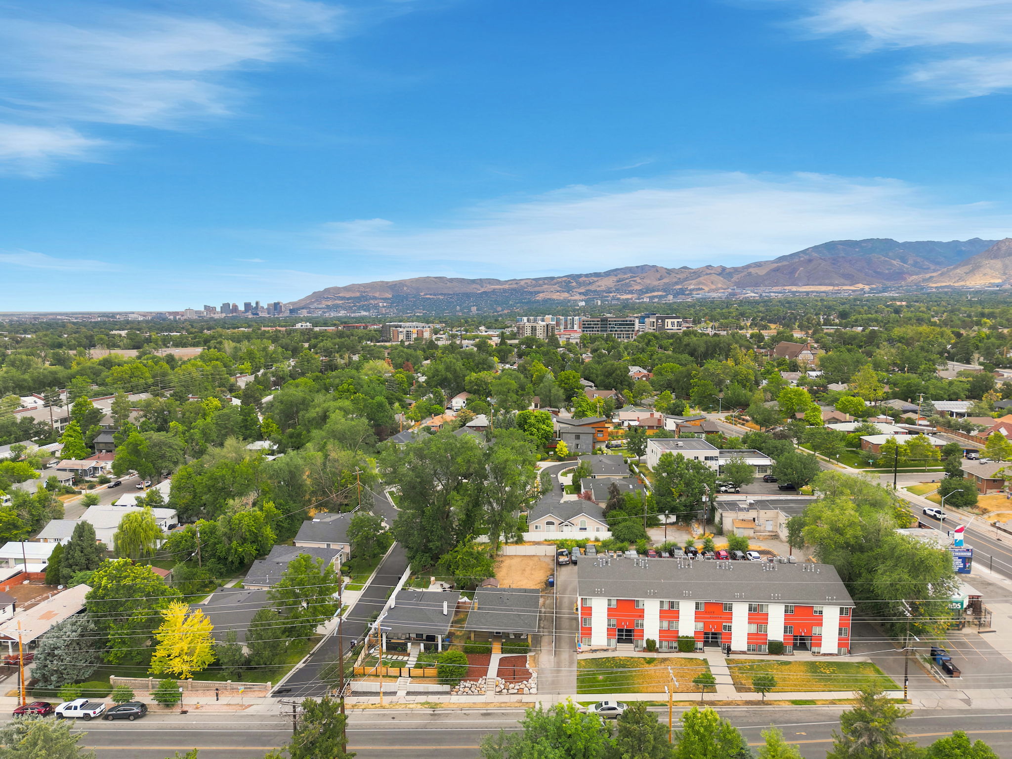 Aerial perspective showcasing the residential and commercial properties, surrounded by mature trees