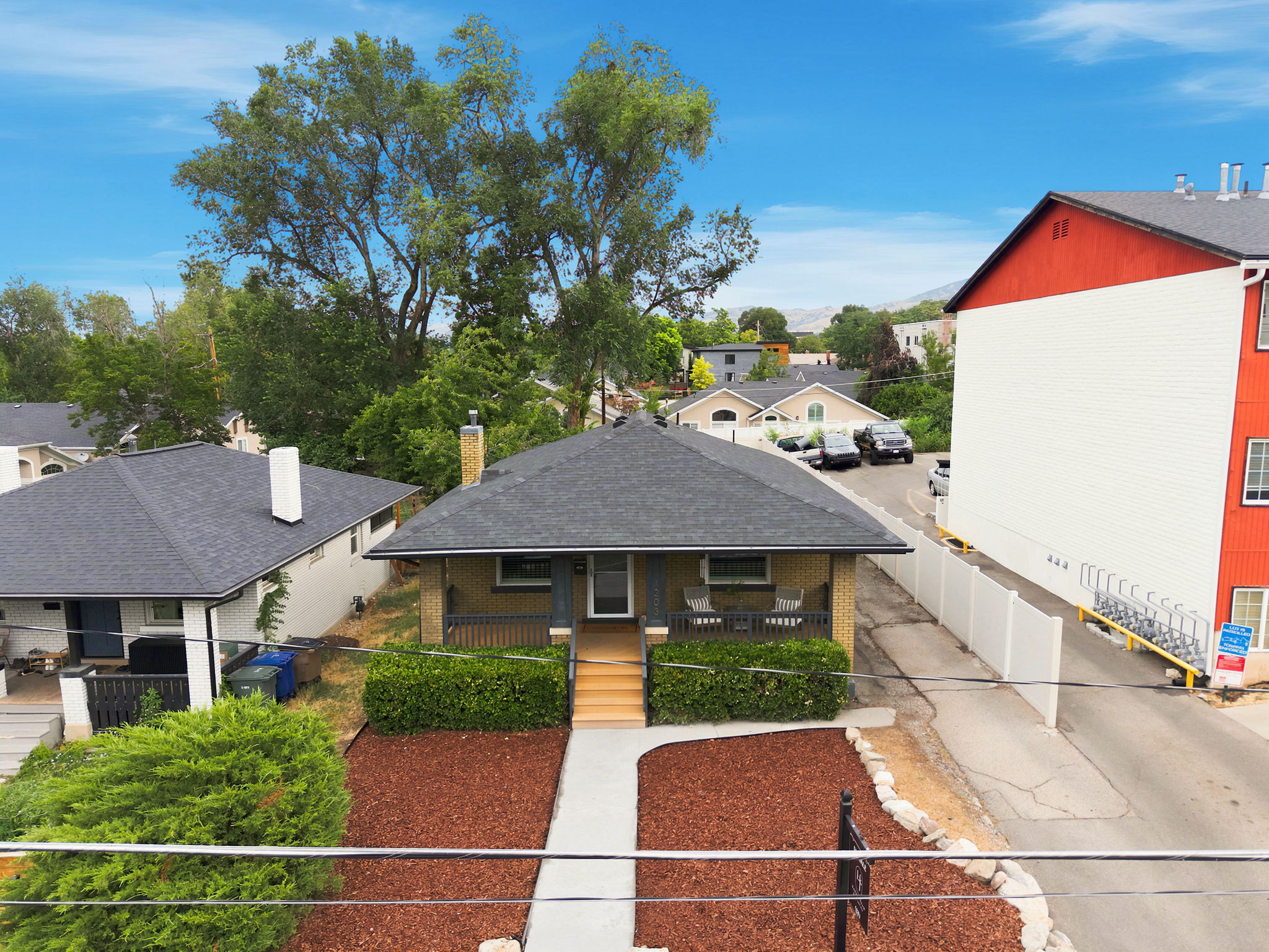 Single-story residence featuring a dark shingle roof, light-colored brick exterior, and a covered front porch