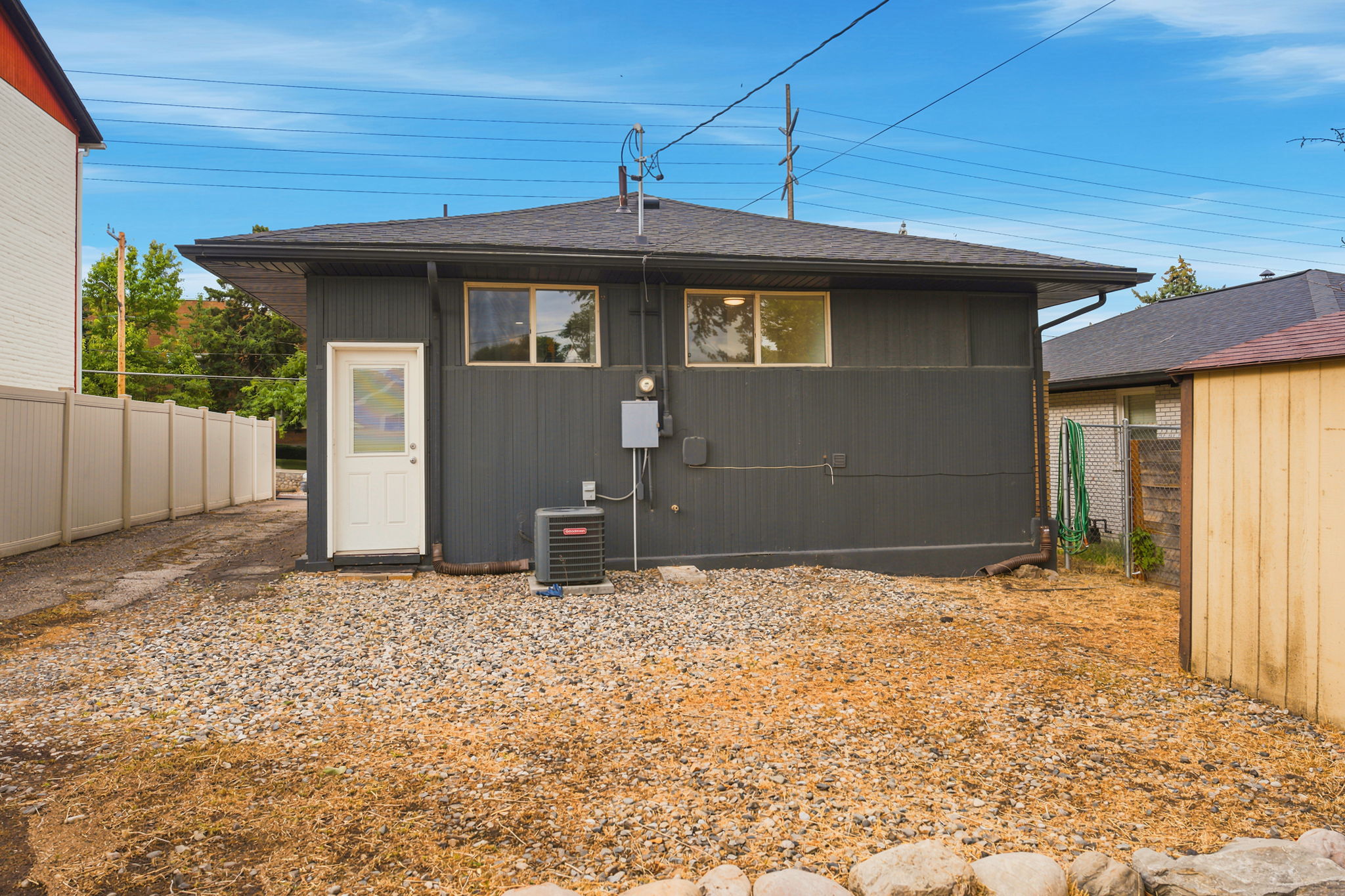 Rear exterior featuring board and batten style siding and a white entry door with inset glass