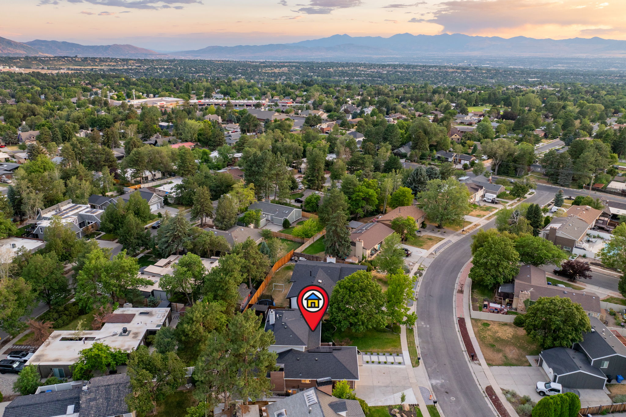 Aerial perspective showcasing a residential neighborhood with abundant mature trees and curving streets