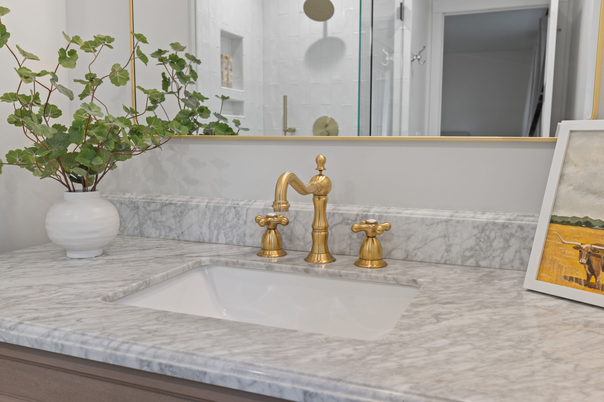 Integrated sink with a polished brass faucet, set within a light-toned countertop featuring a matching backsplash