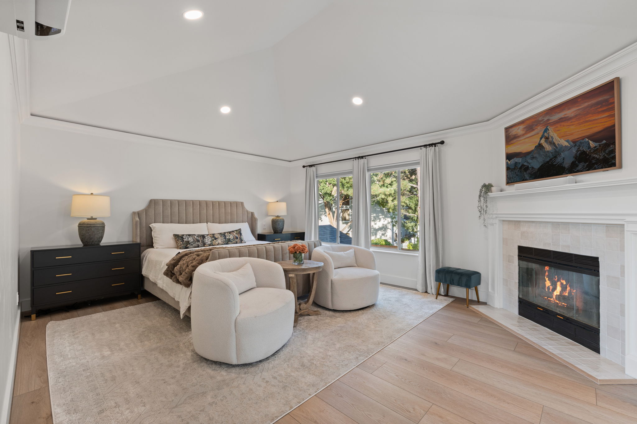Spacious room featuring vaulted ceilings, recessed lighting, and wood-finish flooring