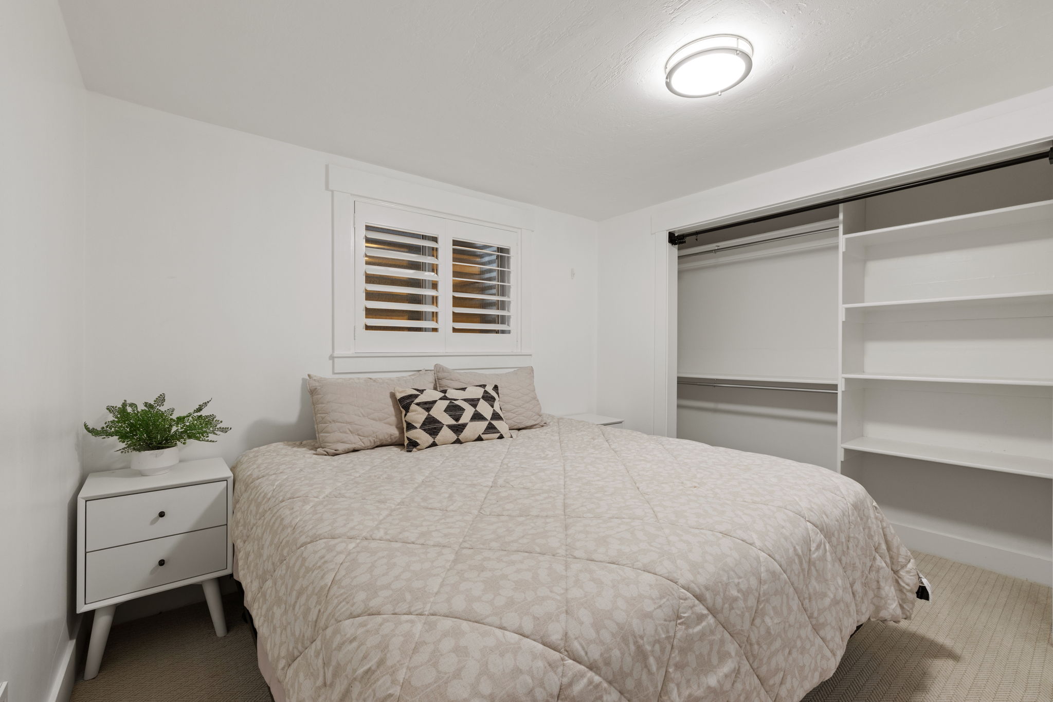Recessed window with white louvered shutters and trim