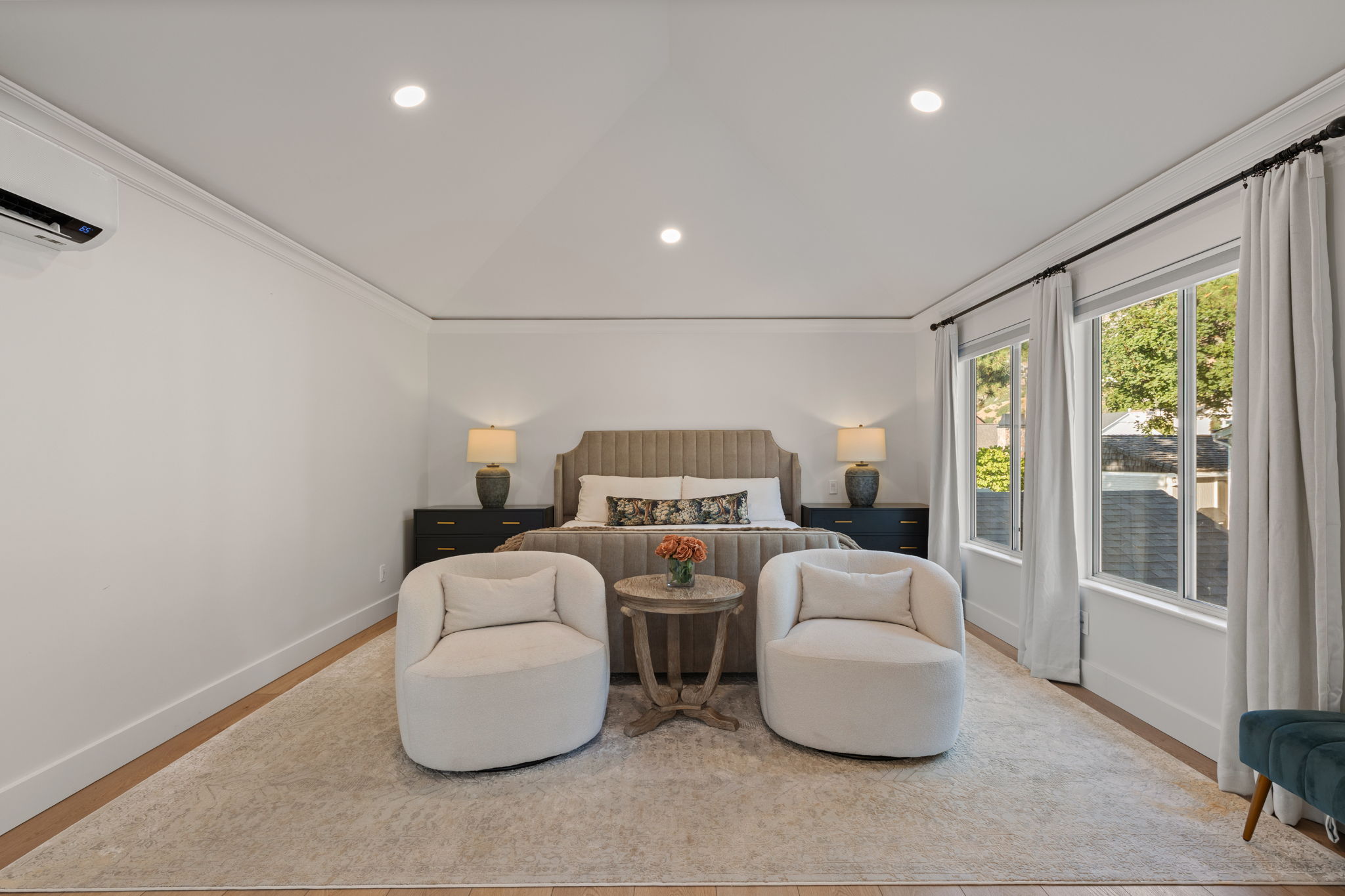 Spacious room featuring wood-finish flooring, recessed lighting, crown molding, and two large windows with curtain rods