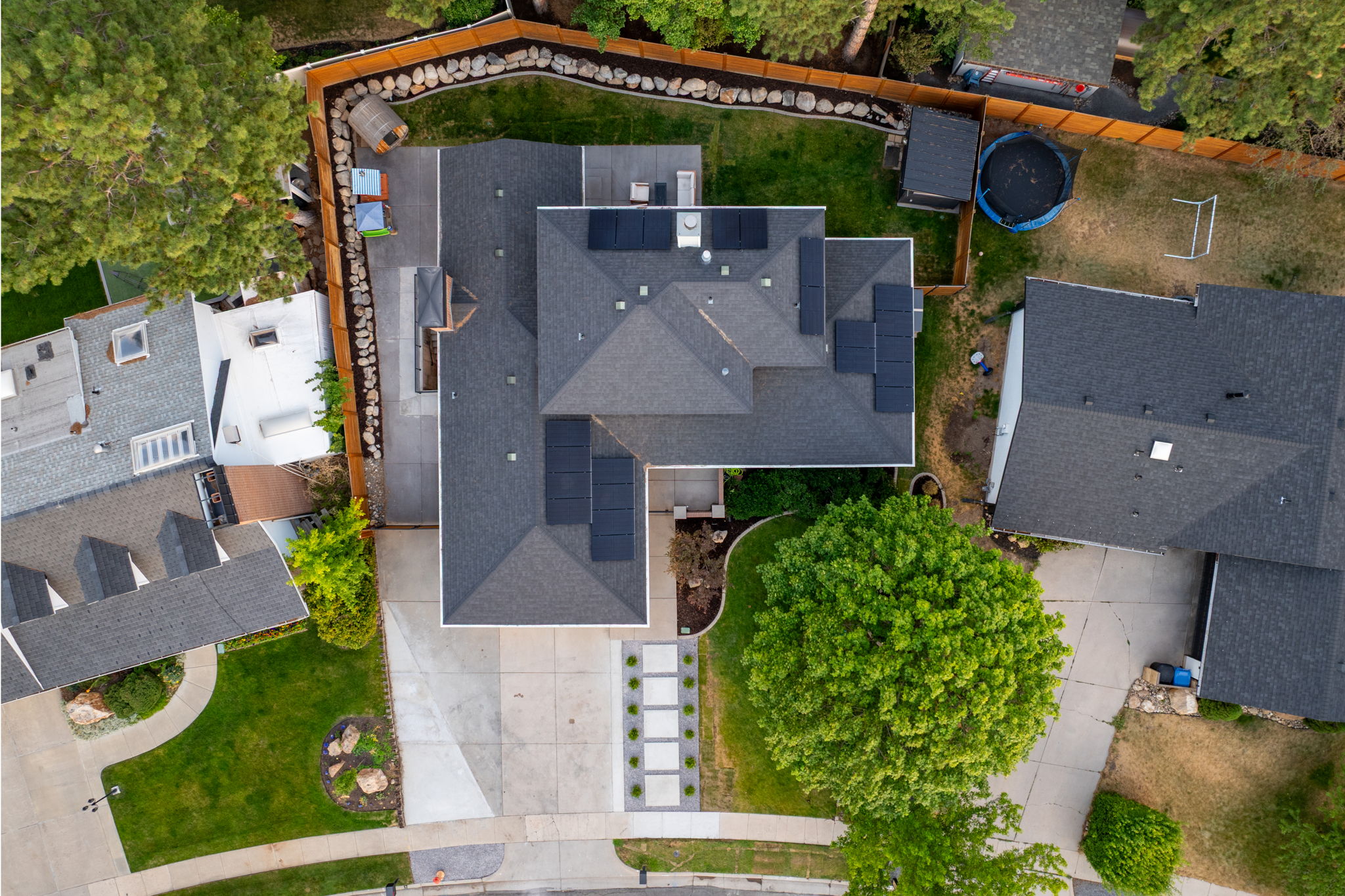 Asphalt shingle roof with multiple solar panel installations