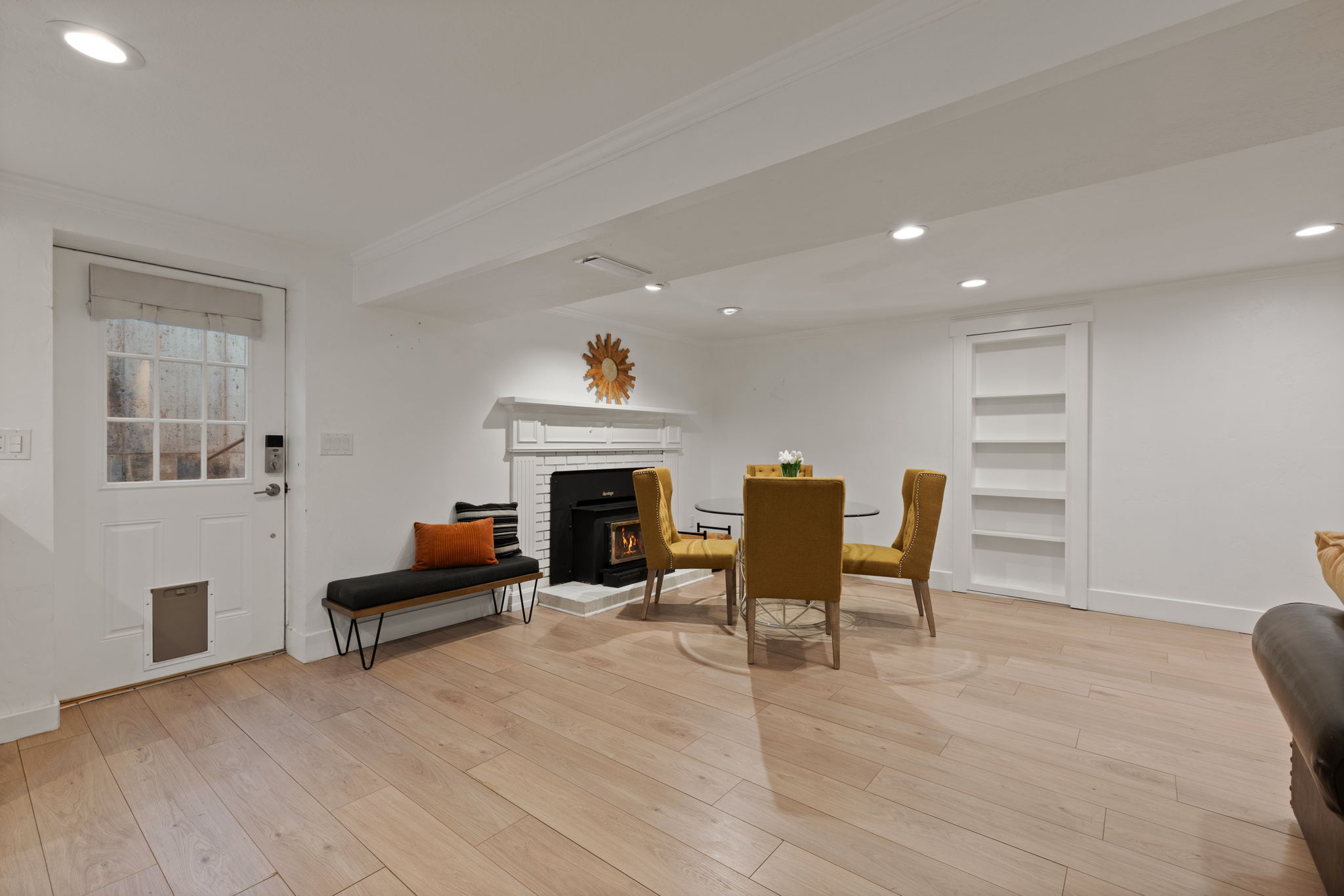 Light wood-finish flooring complements the white walls and recessed lighting