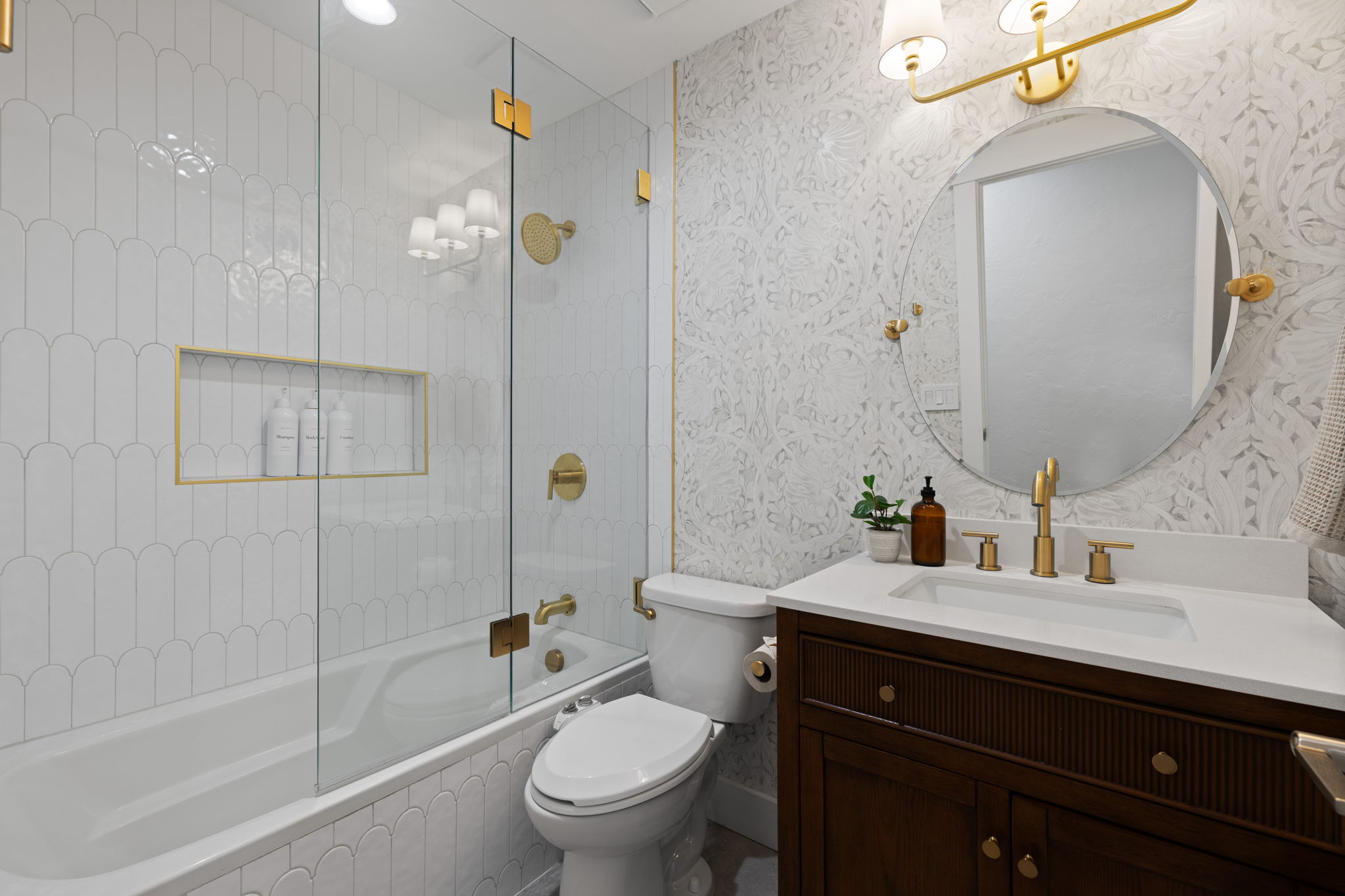 Bathroom featuring a dark wood vanity with a white countertop and gold-finish fixtures