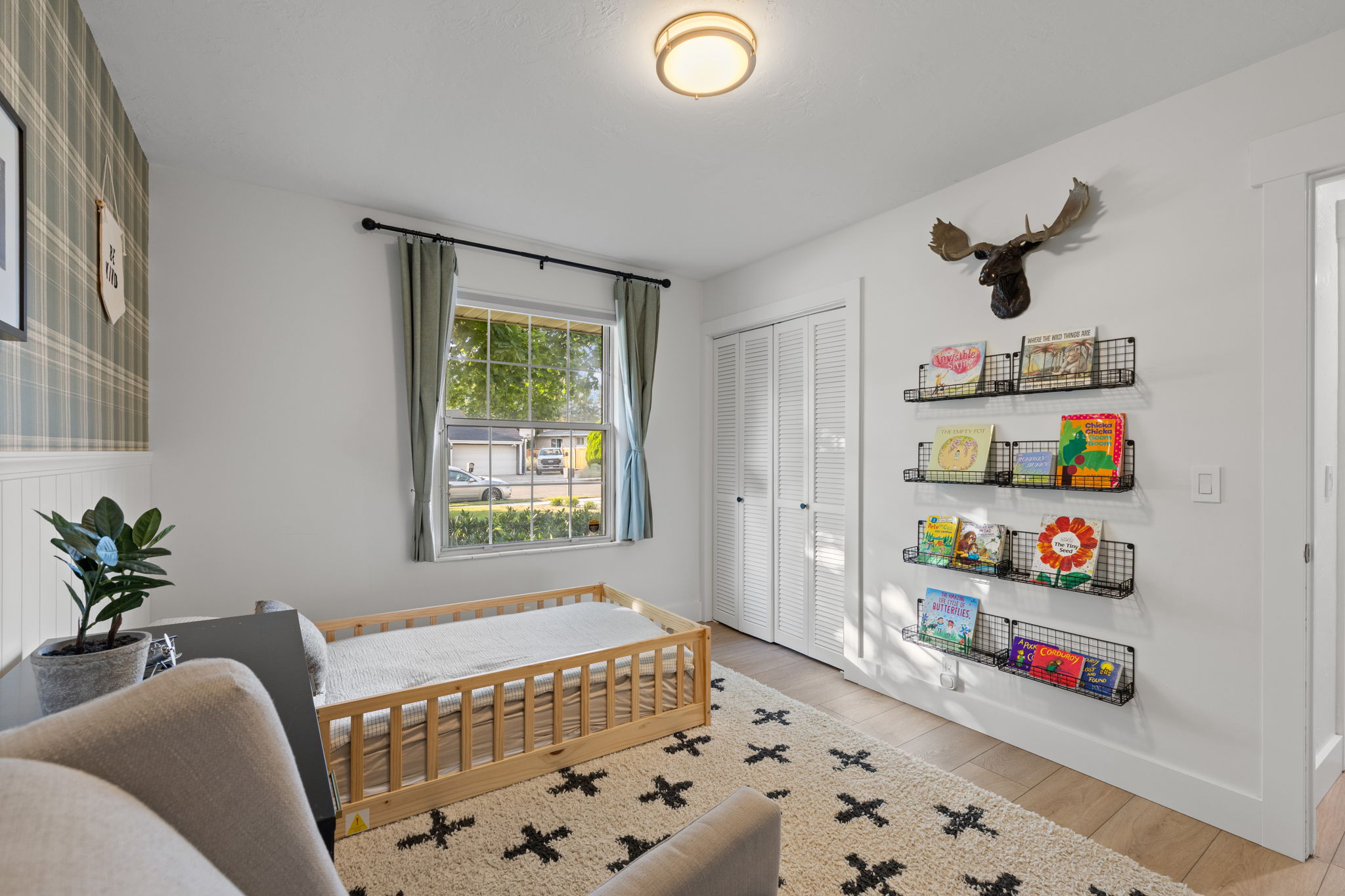 Room featuring wood-finish flooring, a window with exterior views, and a ceiling-mounted light fixture