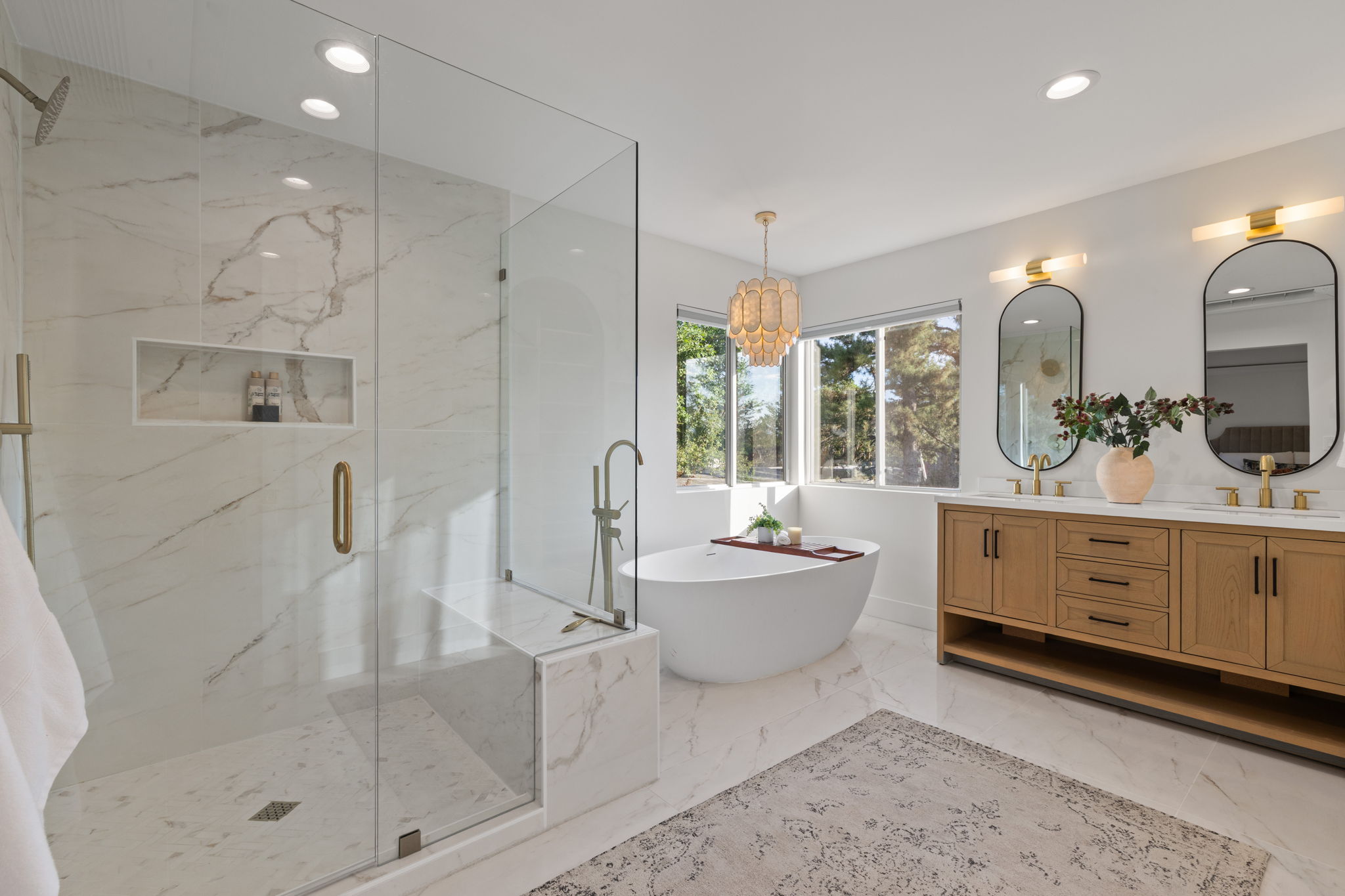 Walk-in shower with clear glass enclosure and built-in bench